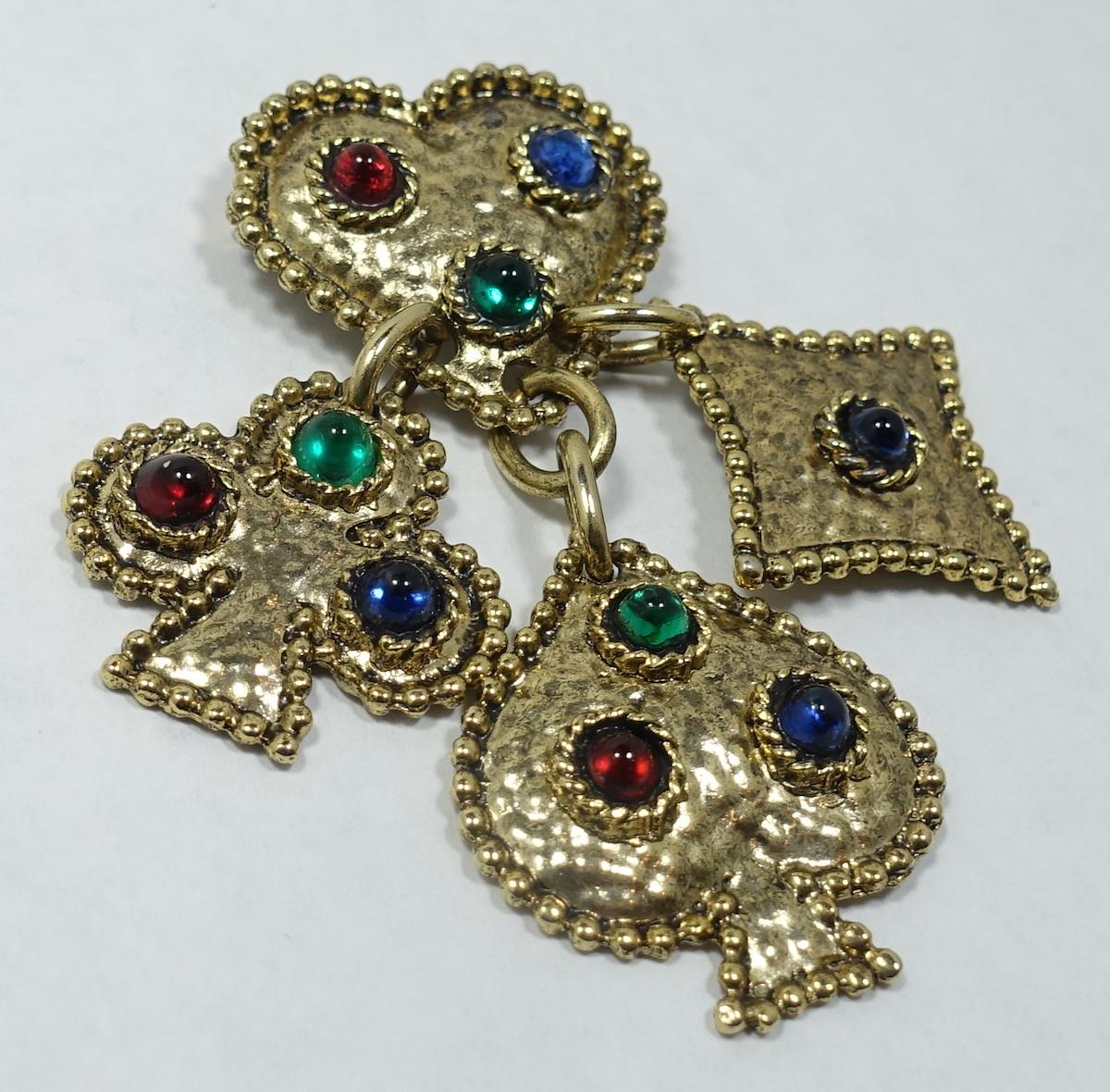 This large French vintage signed Edouard Rambaud brooch features a card theme with hearts, spade, club, diamond symbols with red, blue and green Gripoix cabochon stones in a gold tone setting.  This brooch measures 3-1/2” x 2-1/2” approx and is