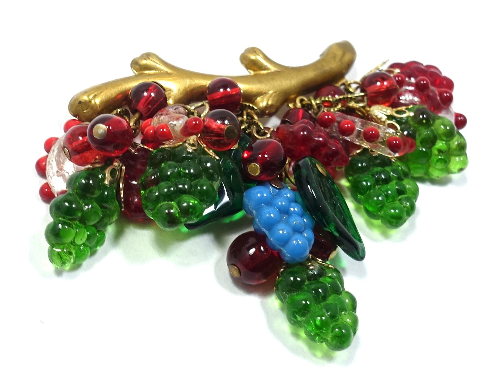 This vintage French Deco 1930s brooch is designed with dangling glass grapes, leaves and multi-color glass berries hanging from a gold tone metal branch.  This brooch measures 2-1/2” x 2-1/4” with a c-pin clasp and is in excellent condition.  
