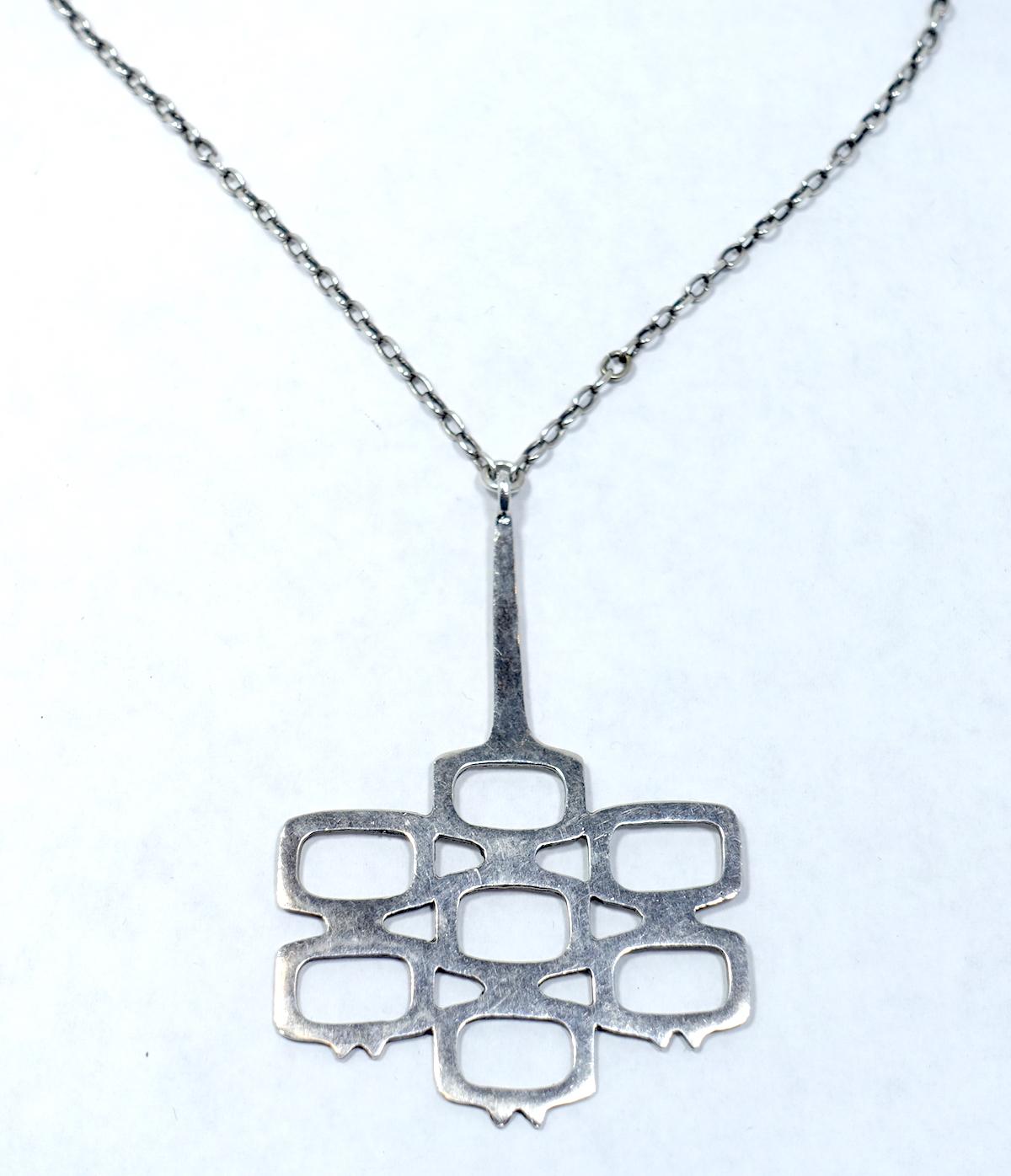 This vintage necklace features an abstract design in a sterling silver setting.  In excellent condition, the pendant measures 3-1/4” x 2-1/4”; the length of the link chain is 21” x 1/8” with a spring clasp.  