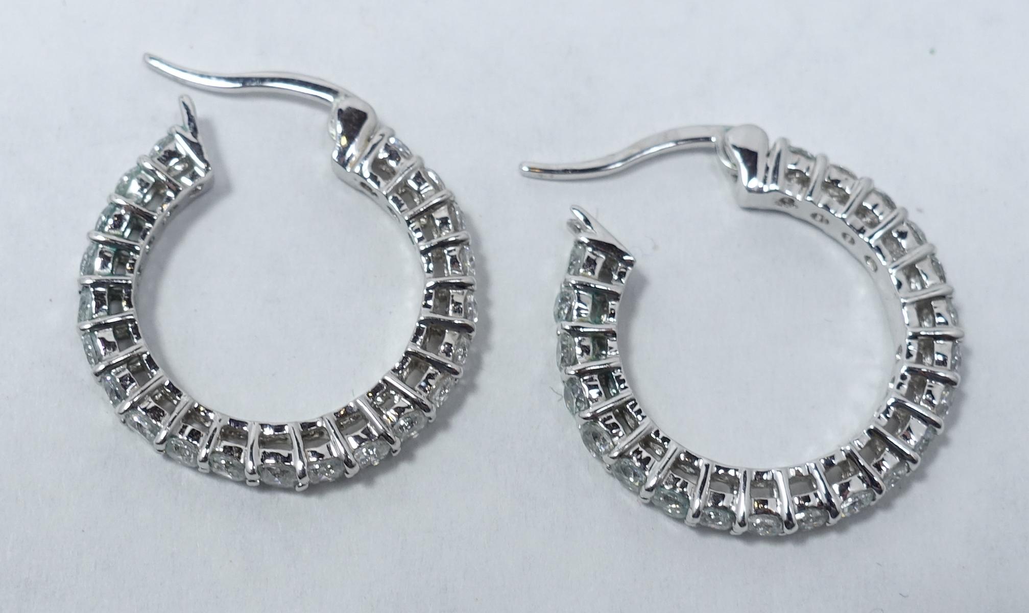 These vintage earrings feature a huggie design with clear crystal going completely around in a silver tone setting.  These pierced earrings look real and measure 7/8” x 1/8” and are in excellent condition.