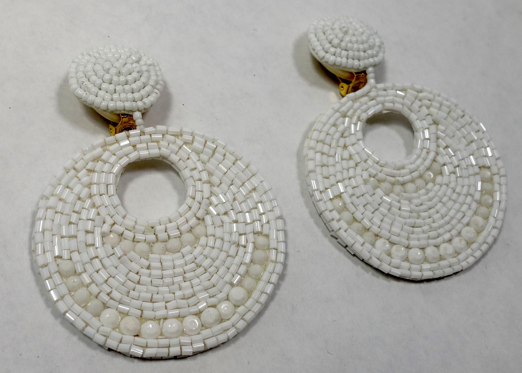 These Kenneth Jay Lane earrings are perfect for the summer.  They feature white beads in a gold-tone setting.  These clip earrings measure 3-1/2” x 2-3/8” and are signed “Kenneth Lane”. These earrings are in excellent condition.