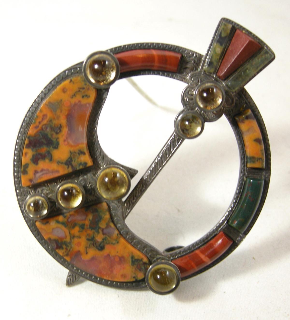This 1880’s Scottish brooch is sterling silver with beautiful speckled agates.  It has citrine cabochons down the middle and on each side.  A scepter, with two more citrine cabochons on top, goes through the brooch.  It is signed on the back with a