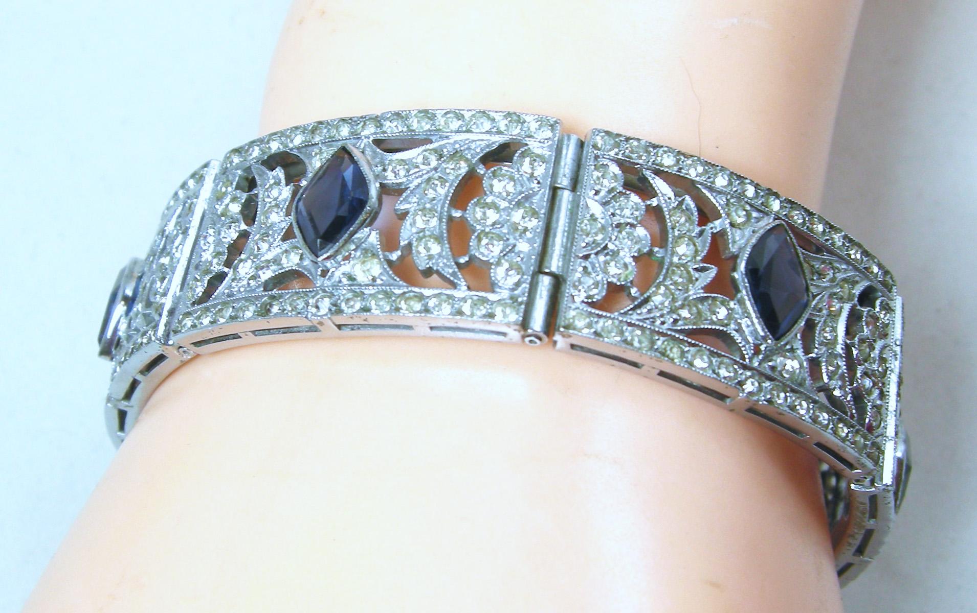 My eyes popped when I saw this bracelet.  I thought it was real.  It has the open work Art Deco design with beautiful clear paste and faux marquis shaped sapphires in the center of each panel.  It has a slide in clasp with a silver rhodium finish. 