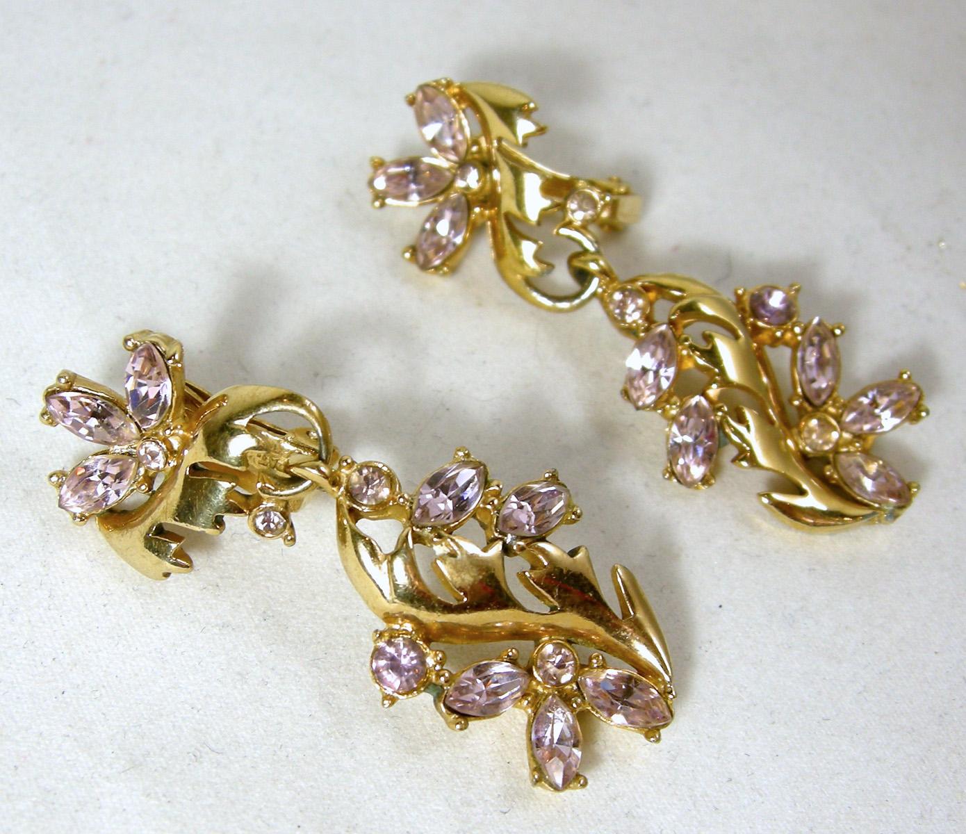 These beautiful Hollycraft dangling clip earrings have light amethyst color rhinestones in a floral design on top.  Dangling below is a gold tone leaf design with more faux amethyst flowers.  They measure 1-7/8” long x 5/8” wide.  They are signed