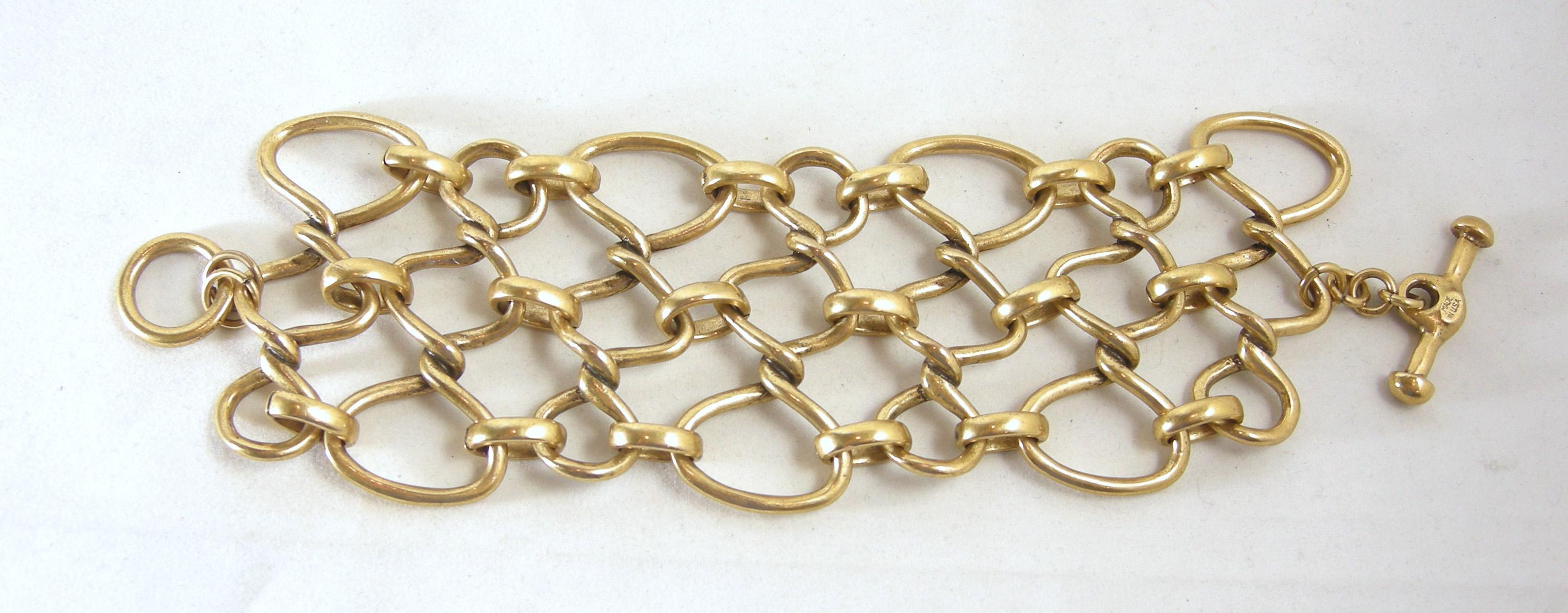 This is a vintage Oscar de la Renta bracelet has a twisted bottleneck chain design in a gold tone finish. It has a toggle clasp that is signed “Oscar de la Renta” and “Made in the USA”.  It measures 7-1/2” long x 3” wide.  It is in excellent
