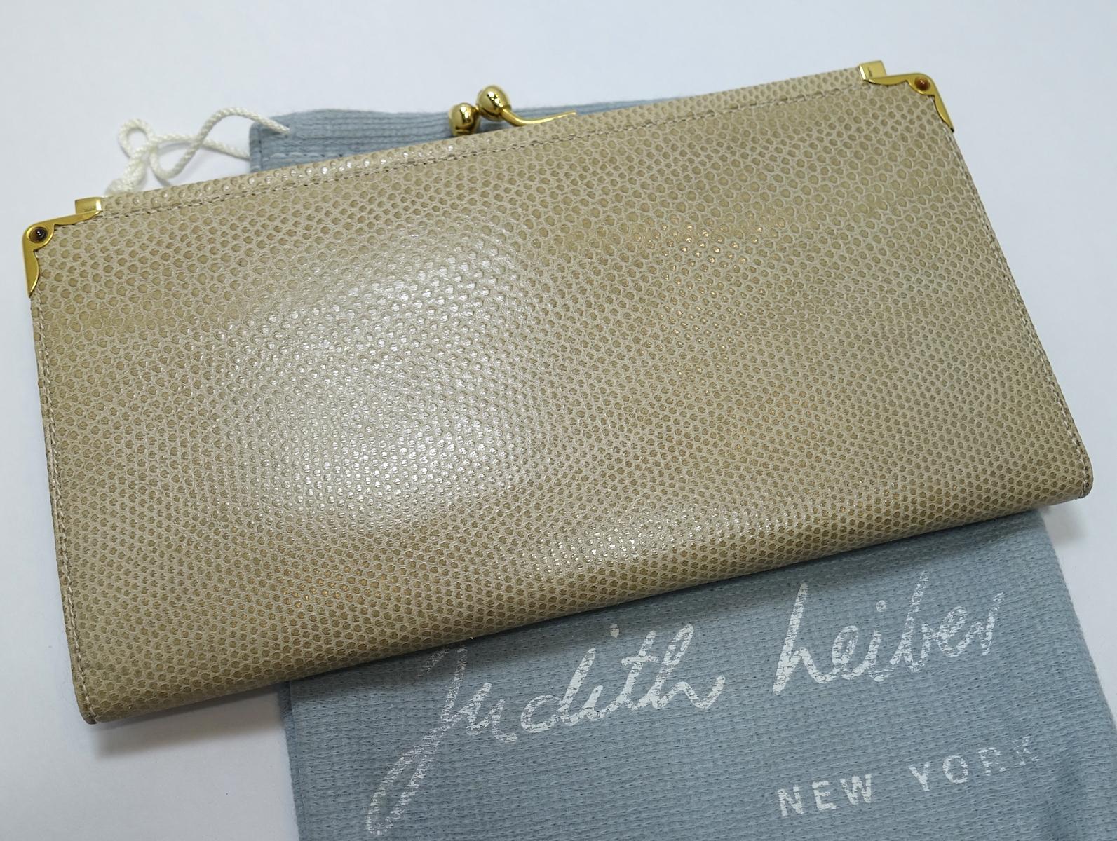 This vintage signed Judith Leiber wallet features a change purse with snap closure. Inside have a zipper compartment and a check holder slide pocket with gold tone snap clasp.  This change purse wallet measures 7-1/4” x 4” and is signed “Judith