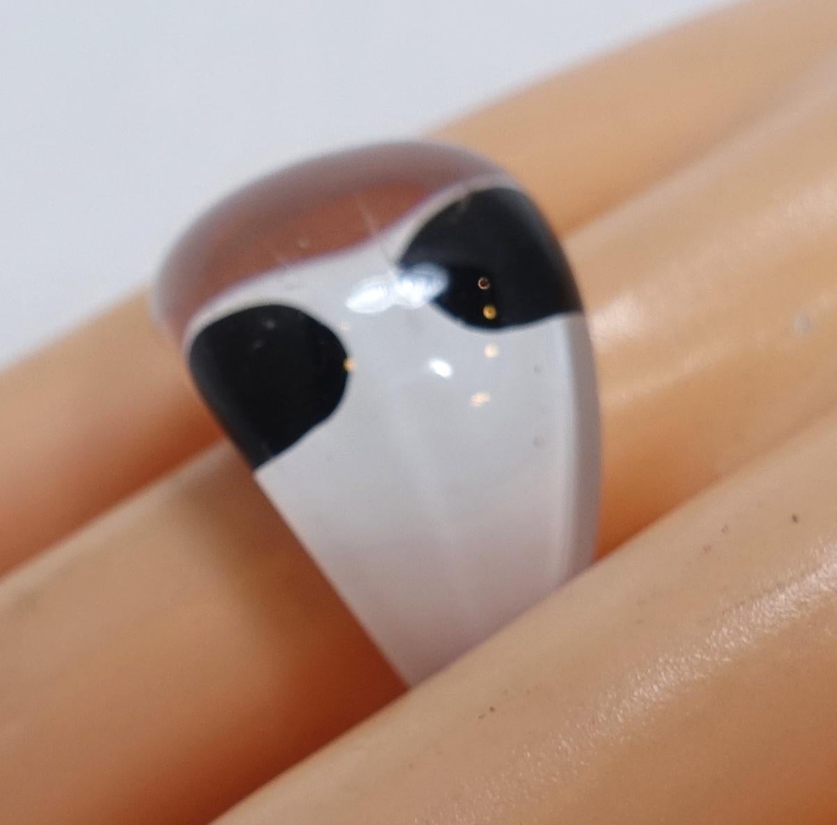 This vintage 1960s Lucite ring features a black & white design.  In excellent condition, this ring is a size 7.5 and measures 3/4” wide.