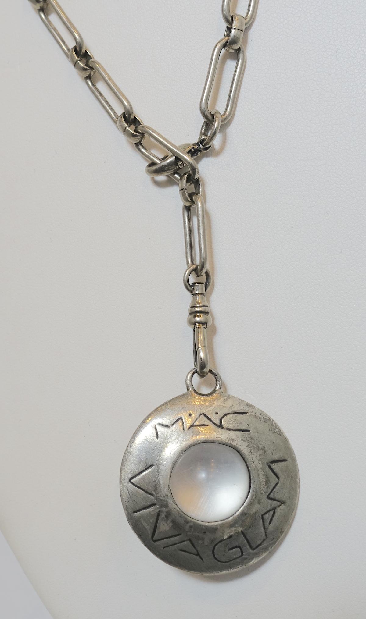 This vintage signed Mac Viva Glam 96 necklace features a pendant with a clear crystal ball center with a large link chain.  The pendant measures 1-3/8” across and the chain is 22” with a spring closure.  In excellent condition, the pendant is signed