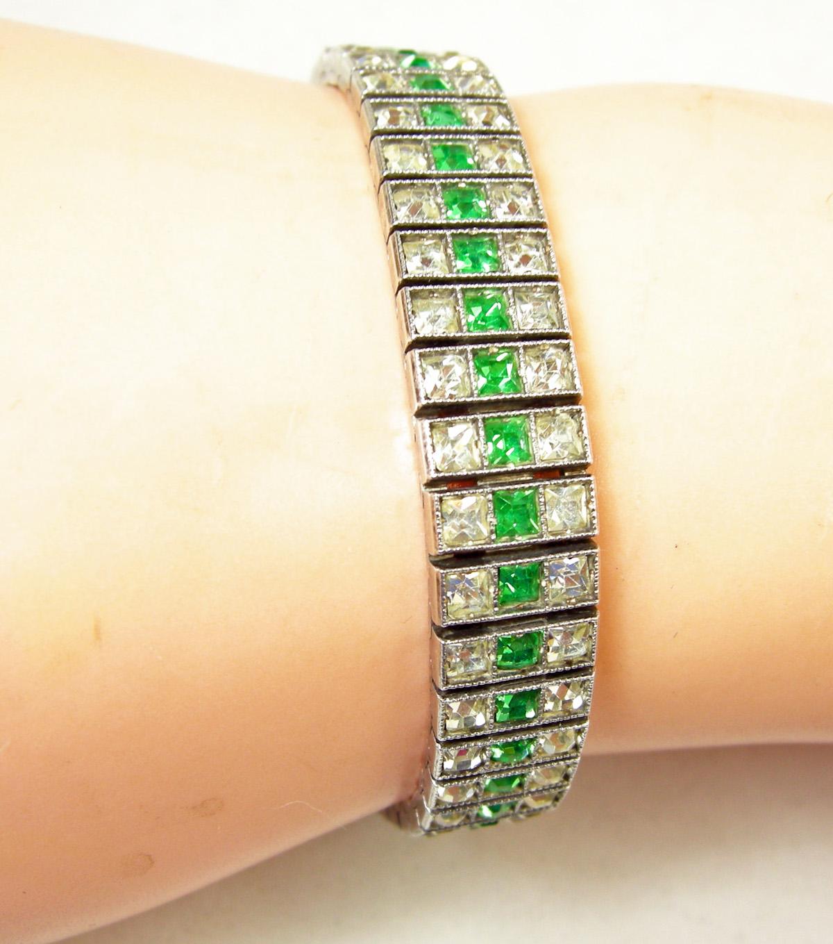 This highly collectible Deco classic channel set bracelet looks real with faux emeralds and paste. It is sterling silver with a push-in slide clasp and marked “Sterling Silver 925”.  The bracelet is 7-1/4” x 1/2