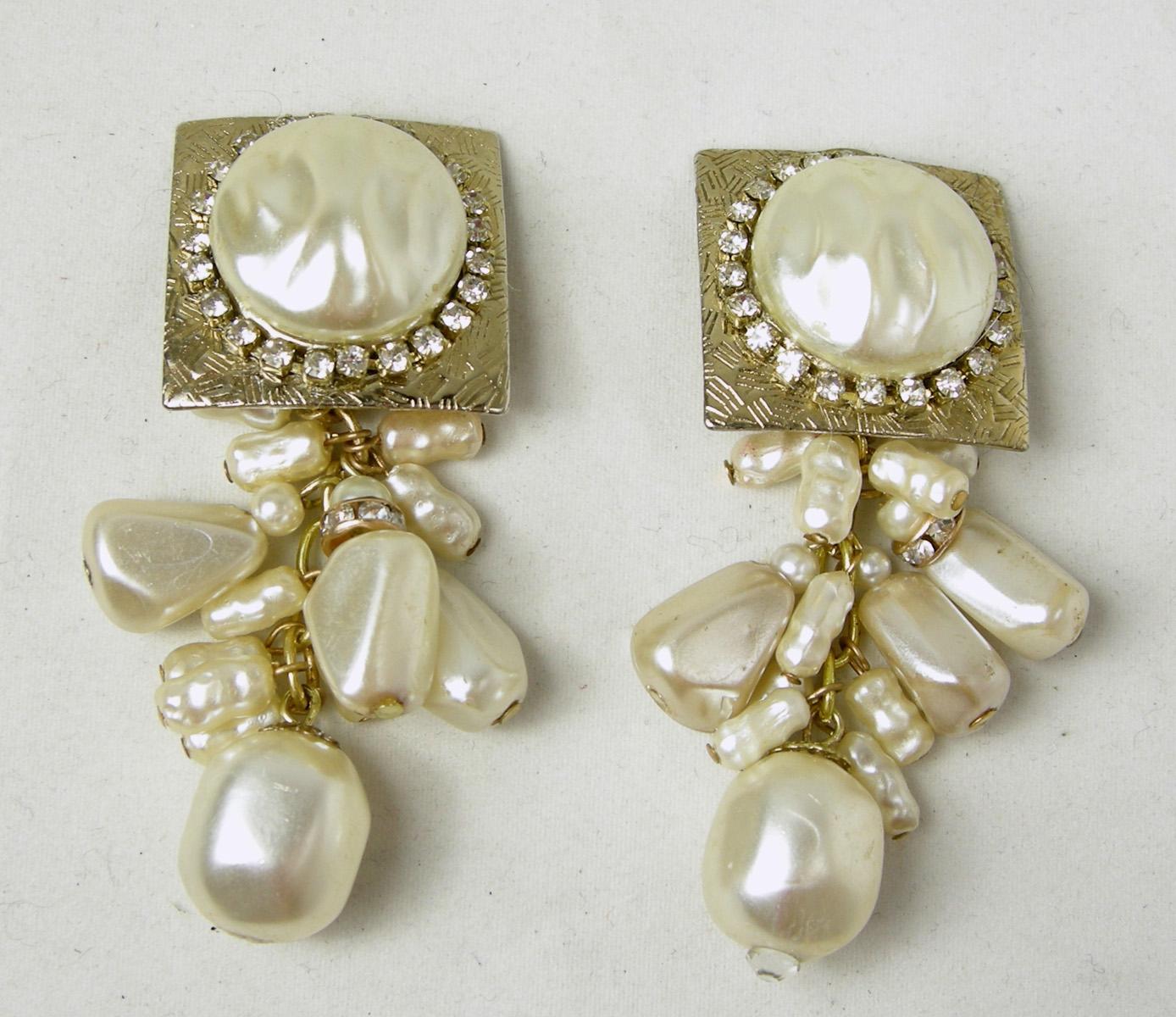 These vintage De Mario Clip earrings have a large faux pearl on top surrounded by rhinestones on a gold tone Florentine square.  Dangling below are different shaped faux pearls.  They measure 2-1/4” long x 1” wide.  They are signed “De Mario” and