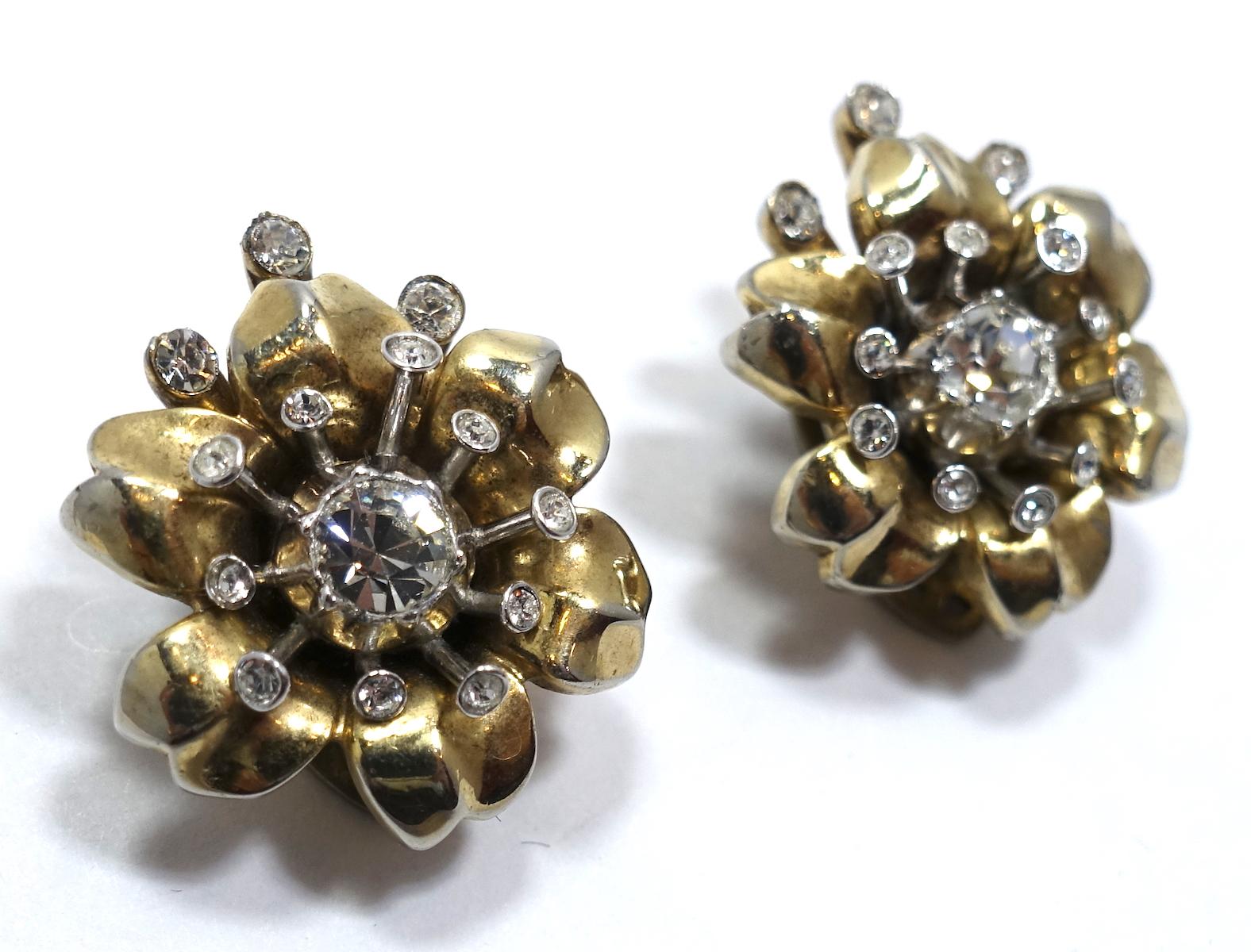 These vintage signed Trifari earrings feature clear rhinestones in a gold tone setting.  In excellent condition, these clip earrings measure 1” x 7/8” and are signed “Trifari”.