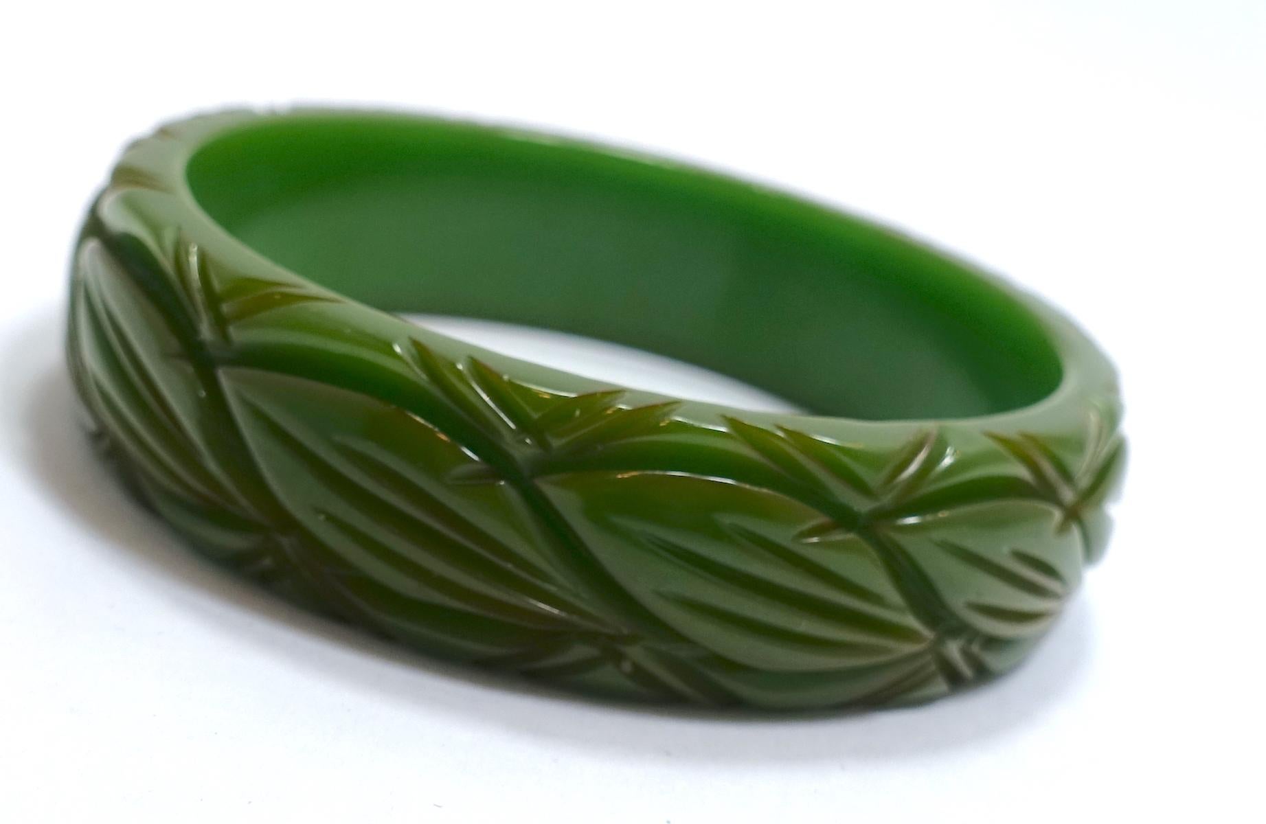 This vintage Bakelite bangle bracelet from the 30s features heavily carved green leaves.  This bracelet measures 8” x 3/4” and is in excellent condition.