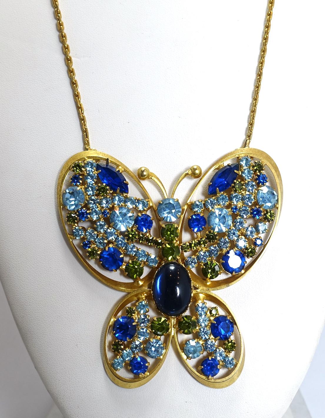 This vintage necklace features a huge butterfly with a large center blue cabochon stone in the middle.  It’s accented with blue and green crystals in a gold tone setting.  The centerpiece measures 3-1/4” x 3” and the chain is 22” x 1/8”.  This