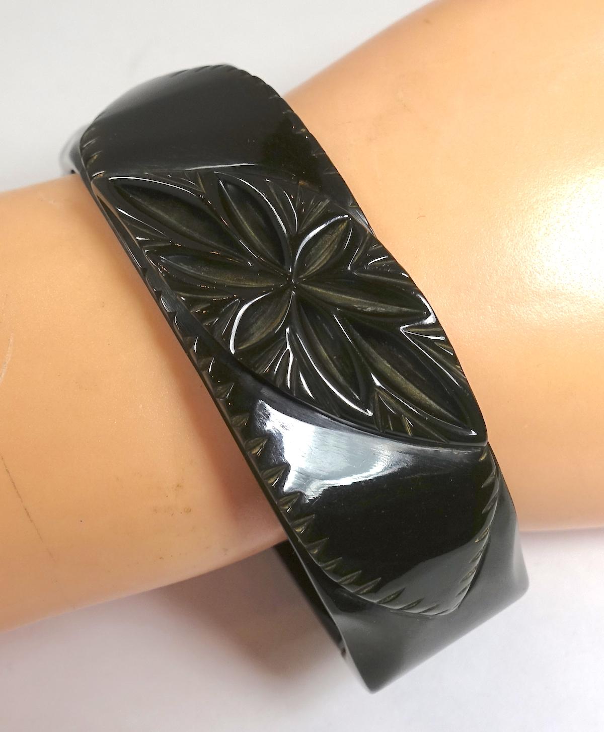 This vintage black Bakelite clamper bracelet features a heavily carved centerpiece.  In excellent condition, this bracelet measures 6-1/2” around the inside x 7/8”.
