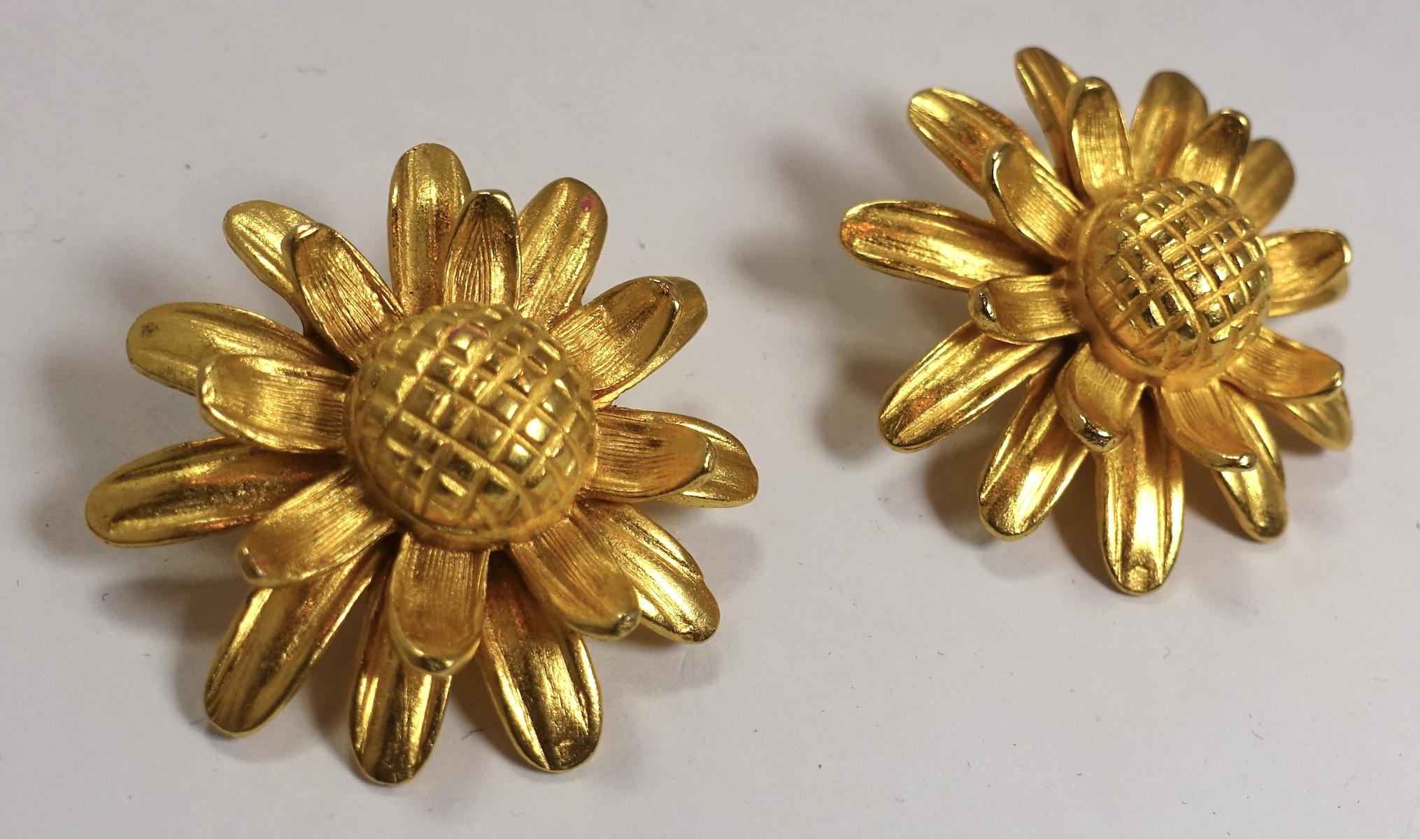 These vintage earrings feature a sunflower design in a heavily etched gold tone setting.  In excellent condition, these clip earrings measure 1-1/2” across.