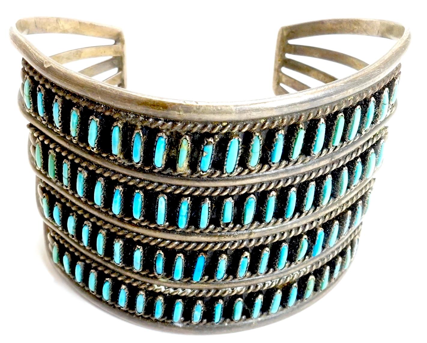 This vintage Zuni Pawn American Indian cuff bracelet features a needlepoint turquoise stone design in sterling silver.  The workmanship and detail to get matching stones to make such a design always amazes collectors.   This adjustable cuff measures