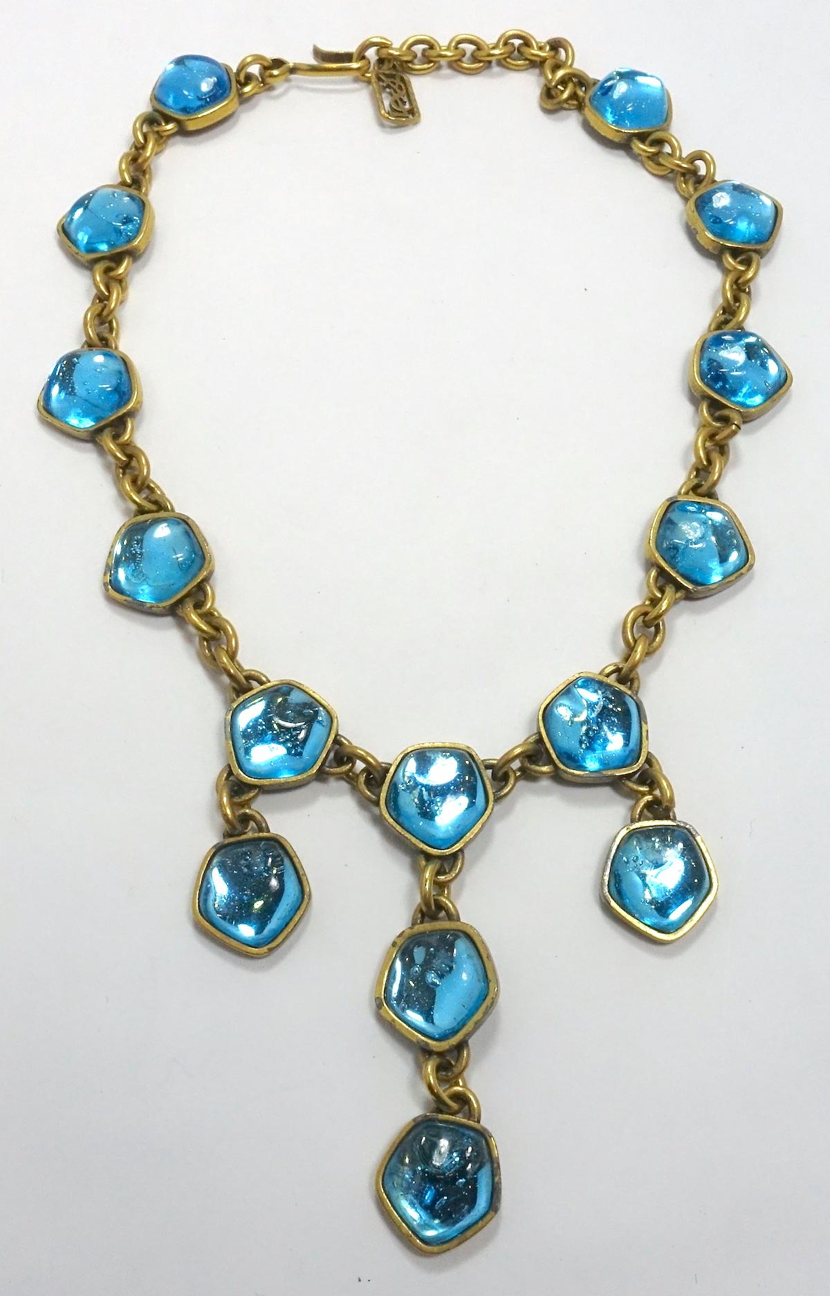 This vintage signed Yves St. Laurent necklace came from a top collection. It is designed with aqua blue poured glass in a gold tone setting.  The necklace measures 17-1/2” x 3/4” with the center drop 3” long (top to bottom).  It is signed “YSL” and