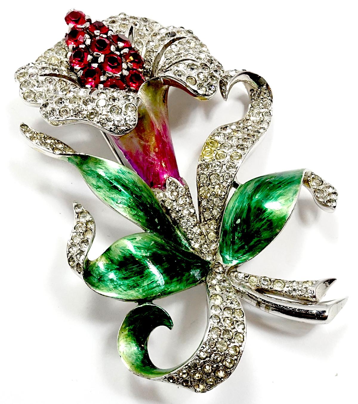 This rare 1940s vintage Marcel Boucher orchid brooch has a 3-dimensional orchid with the leaves with Boucher’s famous enameling of red near the flower and green on the outward leaves. Clear crystals accentuate the leaves and the flower with red