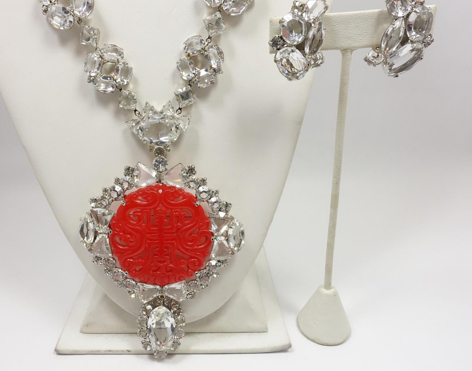 This one-of-a-kind versatile necklace set by Robert Sorrell featuring a red Asian theme as the centerpiece.  The centerpiece can separate from the crystal necklace and can be worn as a brooch.  Brilliant crystals surround the centerpiece in a silver