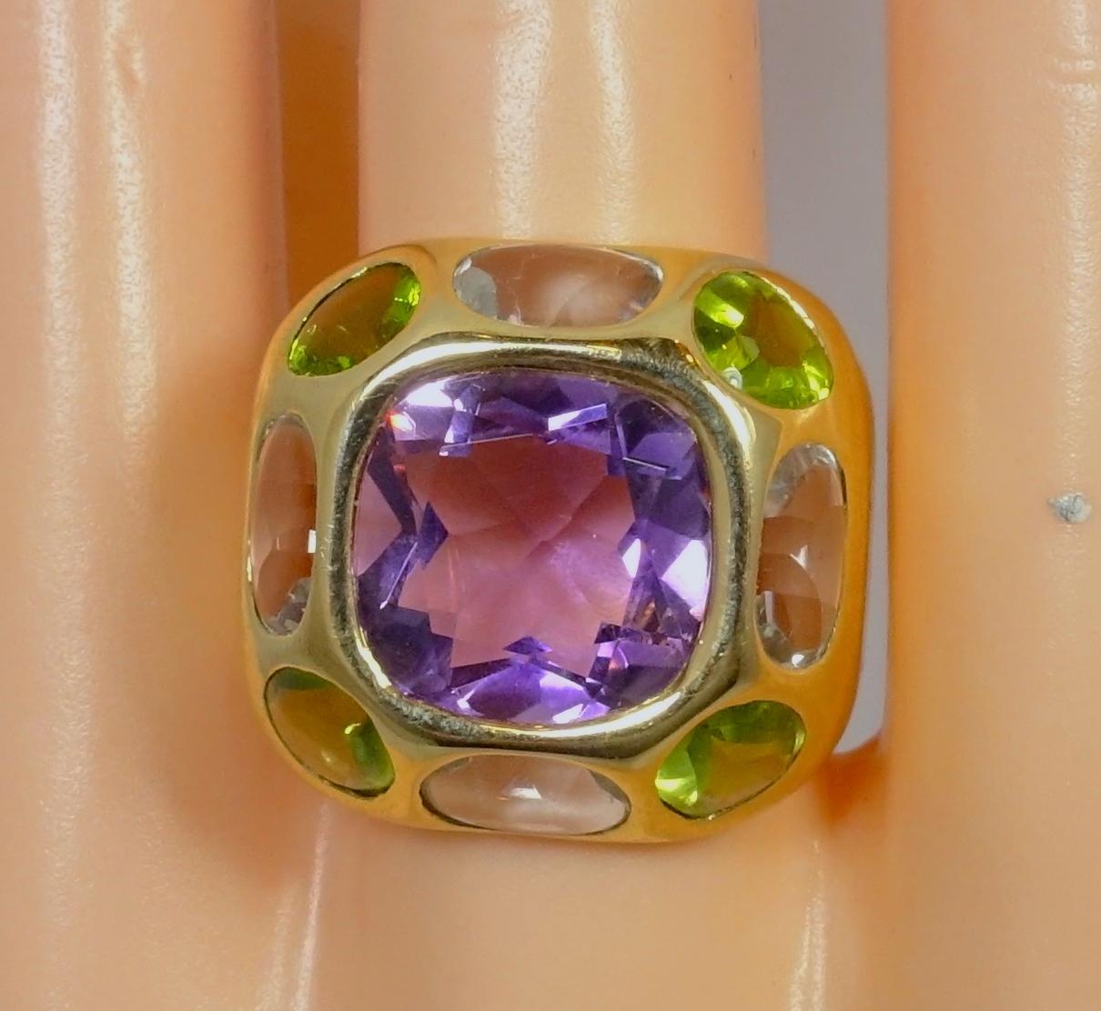 I don’t often come across a great gold Chanel ring like this.  This vintage signed Chanel ring is designed with a large center Amethyst accented by Peridots and Aquamarines gemstones around the amethyst. It’s in an 18kt gold setting.  This ring is a