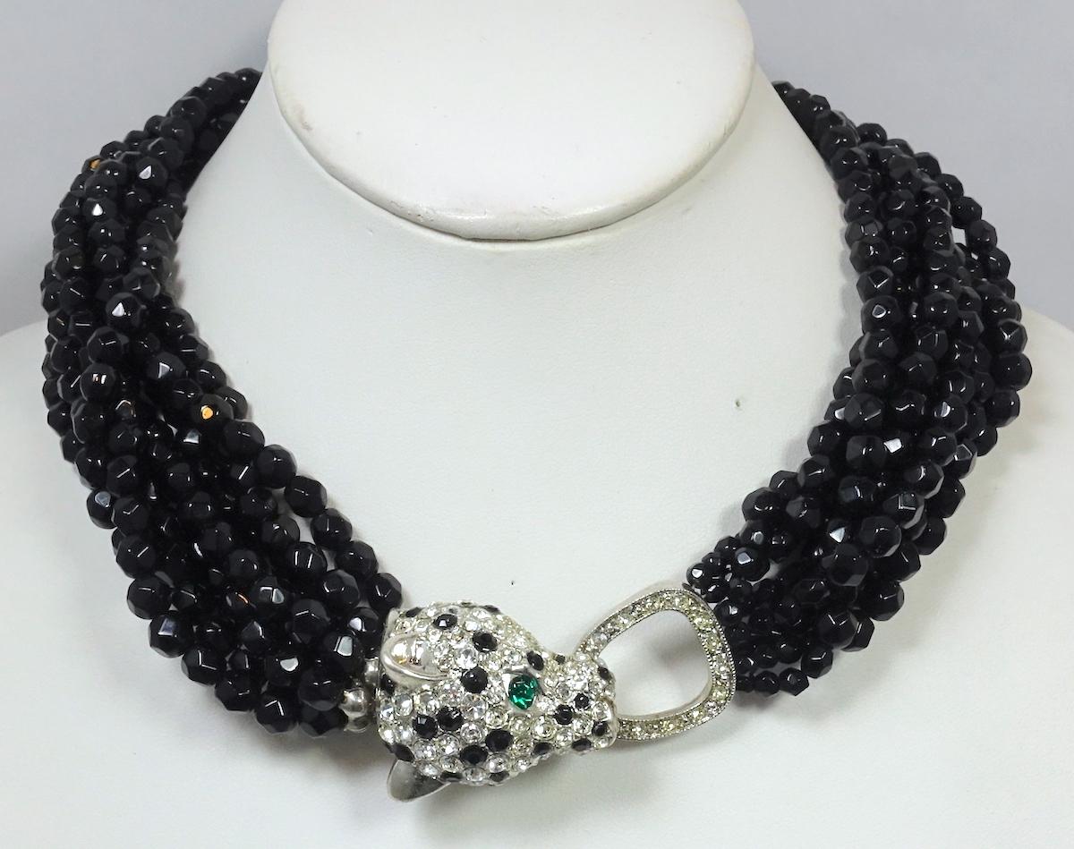 This vintage 1960s Kenneth Jay Lane necklace features a leopard closure with emerald green, black and clear crystals accents leading to 8 strands of black faceted beads.  In excellent condition, this necklace measures 17” and the leopard head is 1”