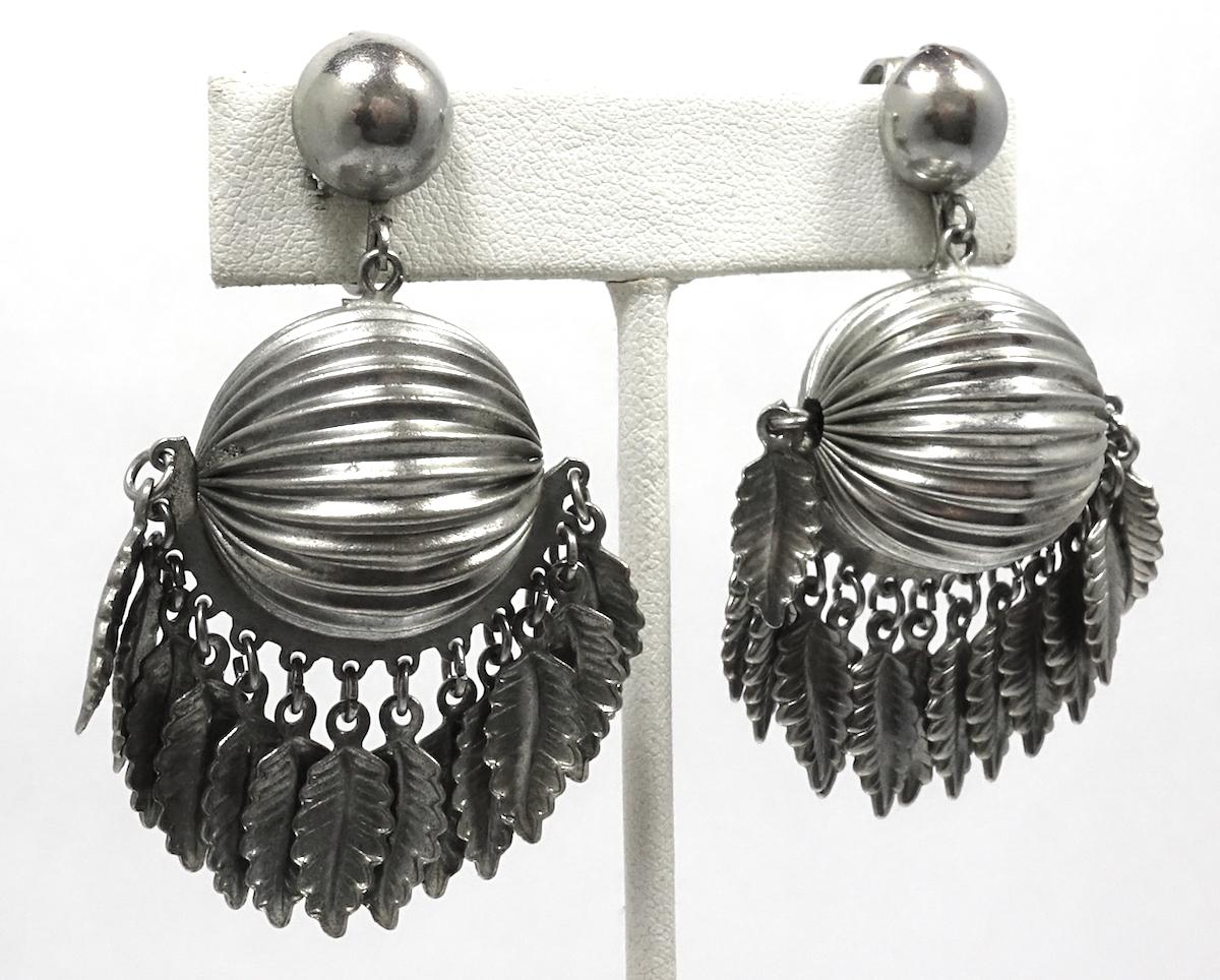 These vintage earrings feature a large ribbed dome with multiple carved dangling leaves below in a silver tone setting.  These clip earrings measure 2” x 1-3/8” and are in excellent condition.
