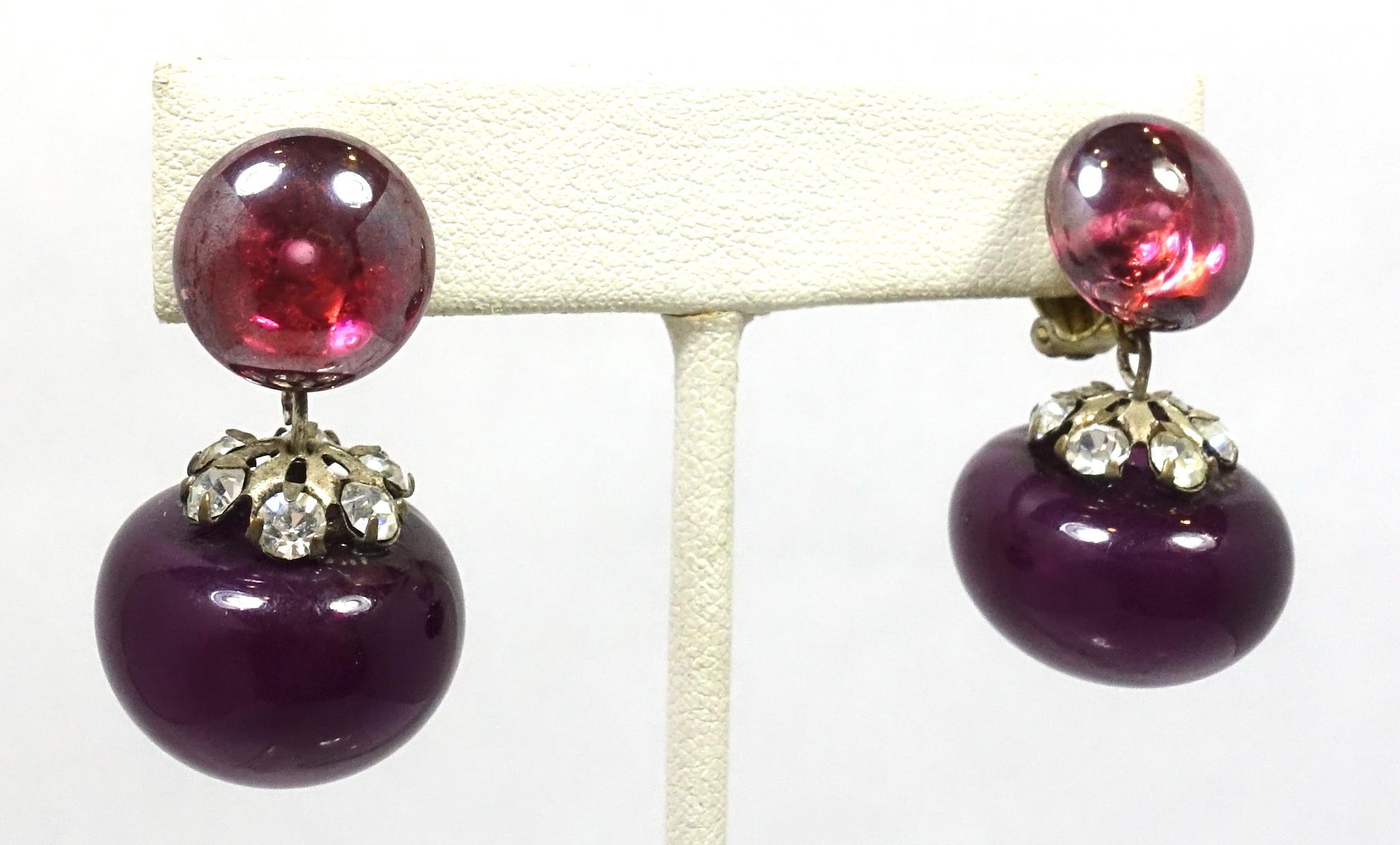 These vintage Art Deco 1920s earrings feature amethyst color drops in a gold tone setting.  In excellent condition, these clip earrings measure 1” x 3/4”.