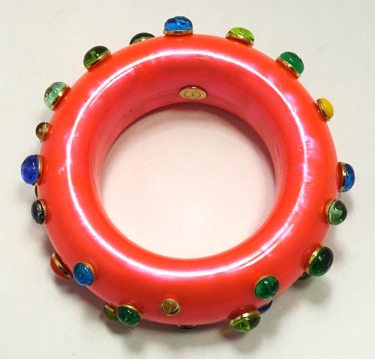 This vintage signed Dominique Aurientis bangle bracelet features multi-color poured glass accents on a marbleized coral color resin.  This bangle measures 7-3/4” around the inside x 1-1/4” wide, is signed “Dominique Aurientis Paris” and is in