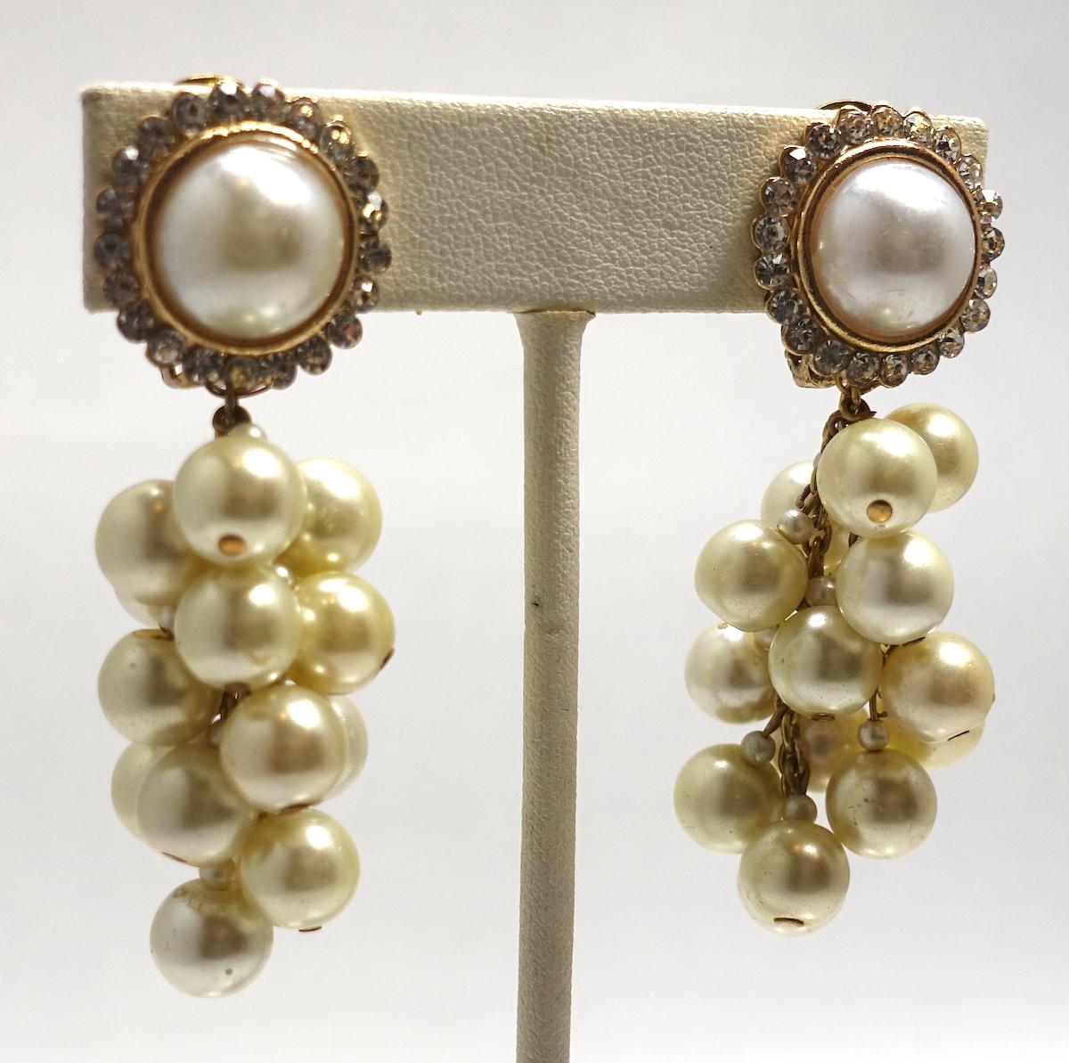 These vintage signed DeMario earrings feature faux pearls with clear crystal accents in a gold-tone setting.  These clip earrings measure 2-1/4” x apx 1”, are signed “DeMario” and are in excellent condition.