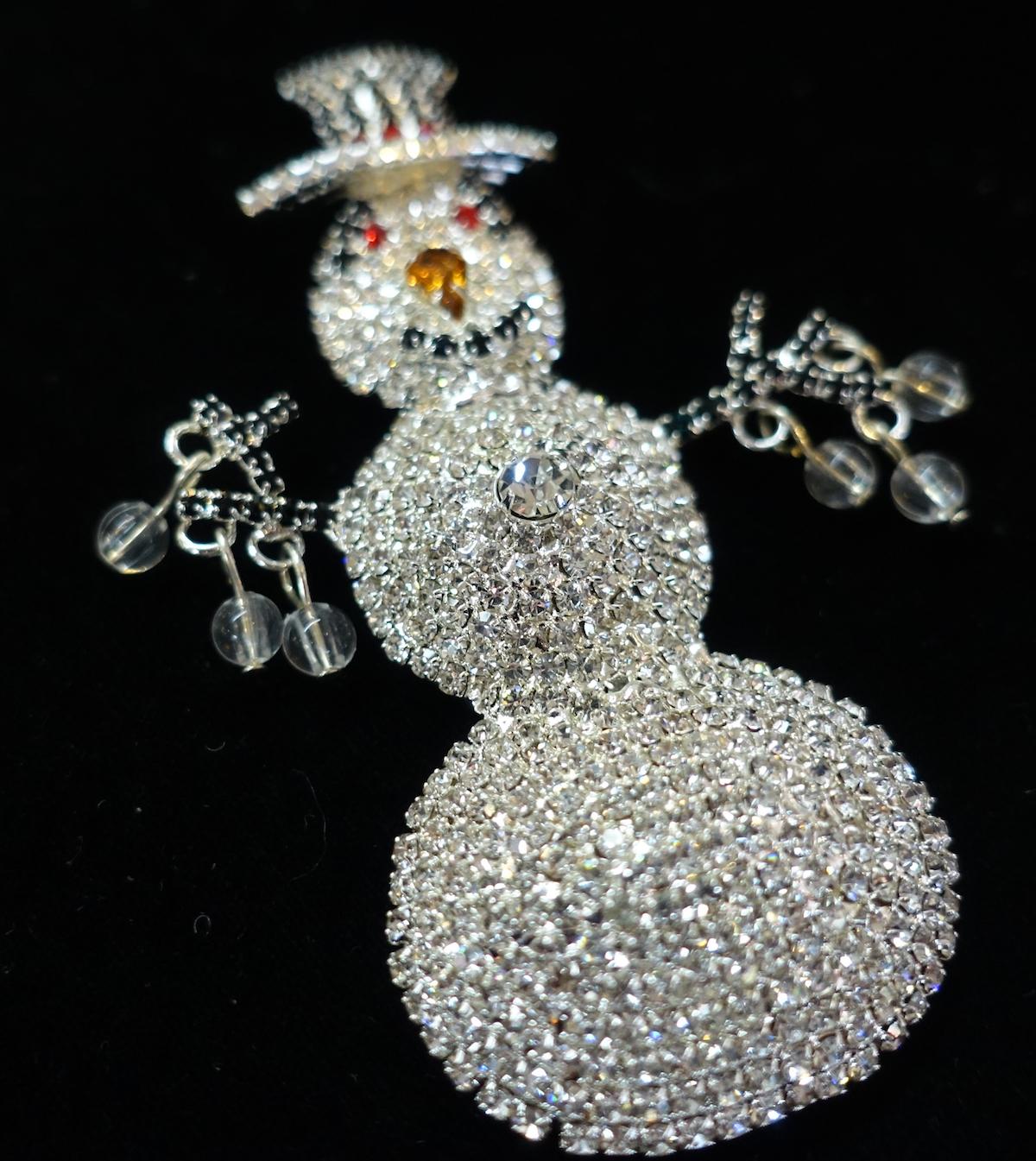 This large brooch features a snowman design with clear, black and red crystals in a silver-tone setting. In excellent condition, this brooch measures 3-3/8” x 2-1/4” and has a turn closure.
