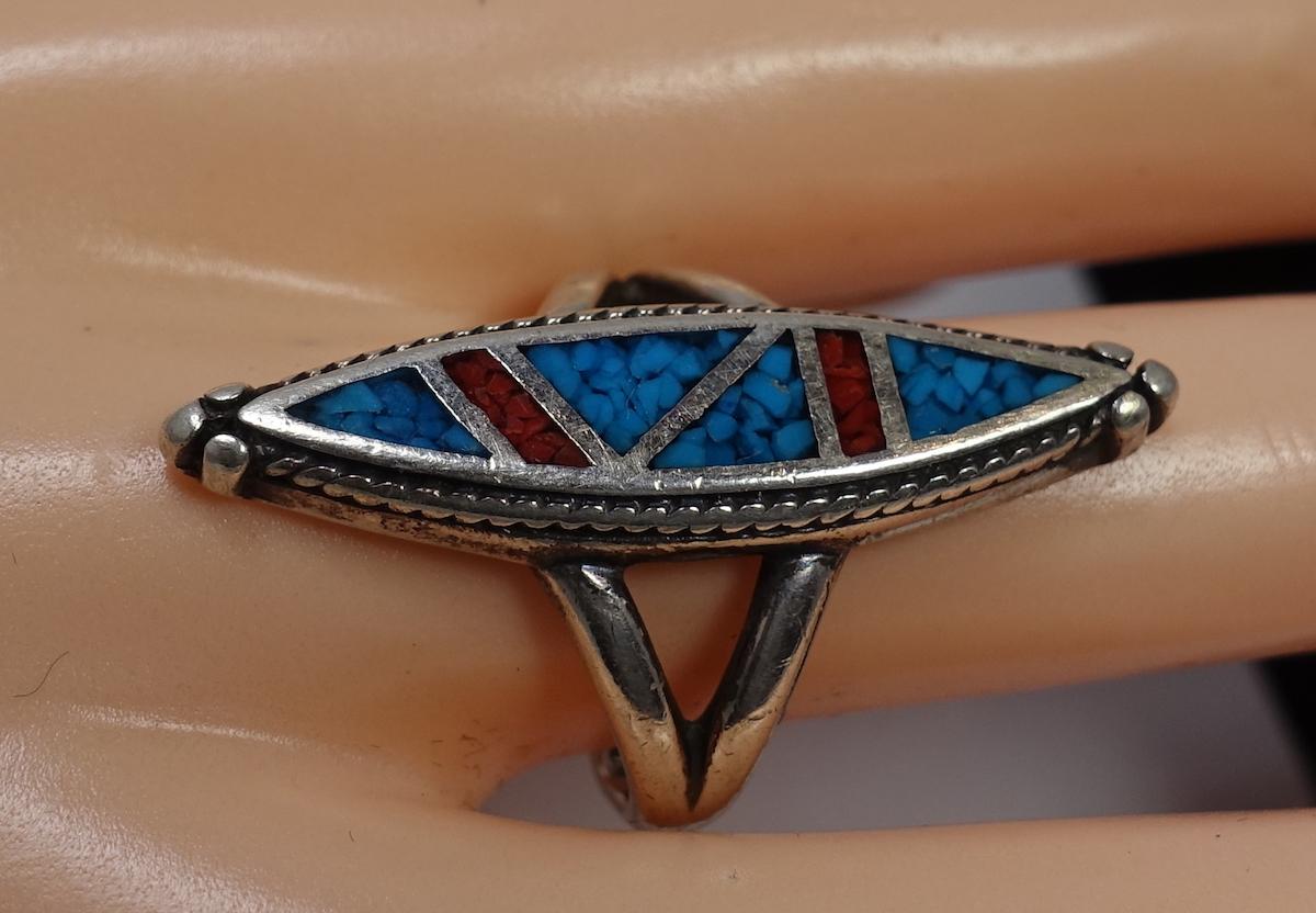 This vintage ring features turquoise and coral stones in a sterling silver setting.  A size 9, this ring measures 1-1/2” x 3/8” across the top and is in excellent condition.