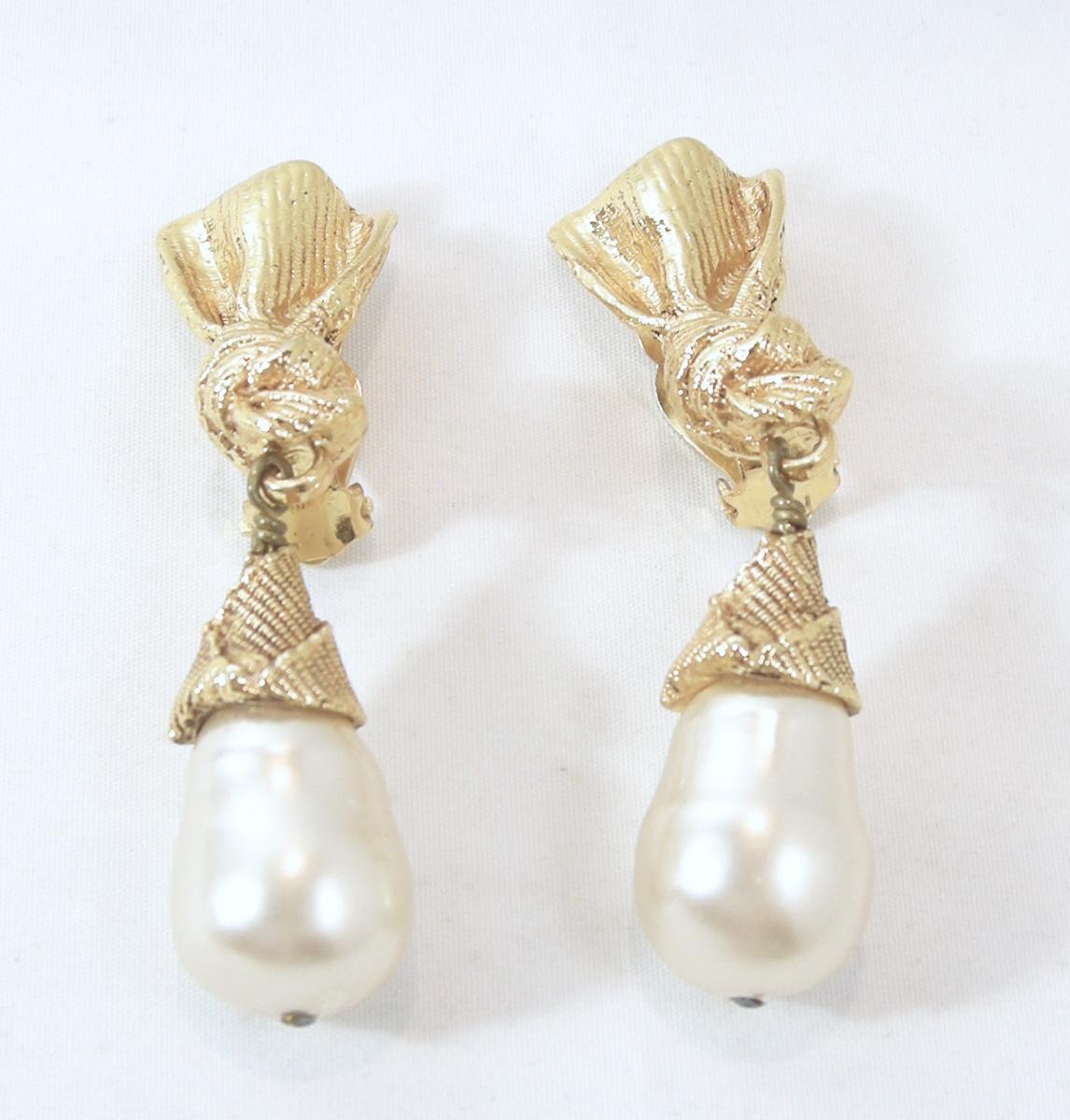 These beautiful clip faux pearl drop earrings are French and signed “Paris” in the back.  The gold tone top has a ribbon design that has a knot at the bottom, which connects to a capped faux baroque pearl. They measure 2-5/8” long x 3/4