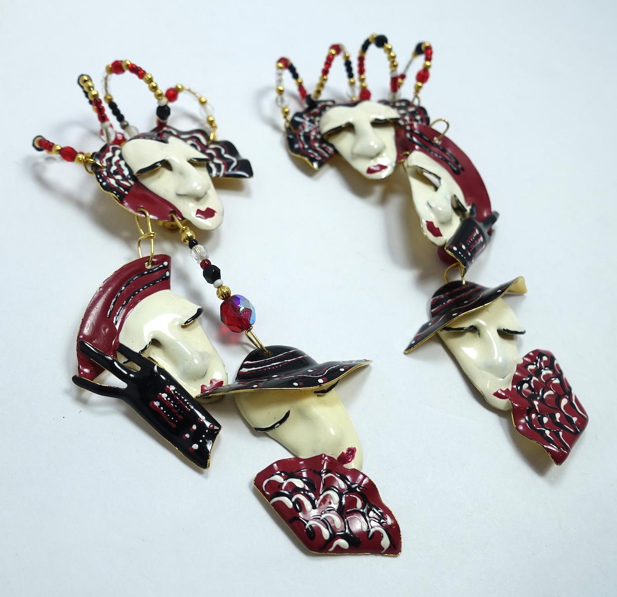 These vintage signed earrings feature multiple faces with black, ivory and red enameling and beads in a gold tone setting.  These clip earrings measure 5” x approx 2-1/2” and are signed “Lunch at the Ritz”.  They are in excellent condition.