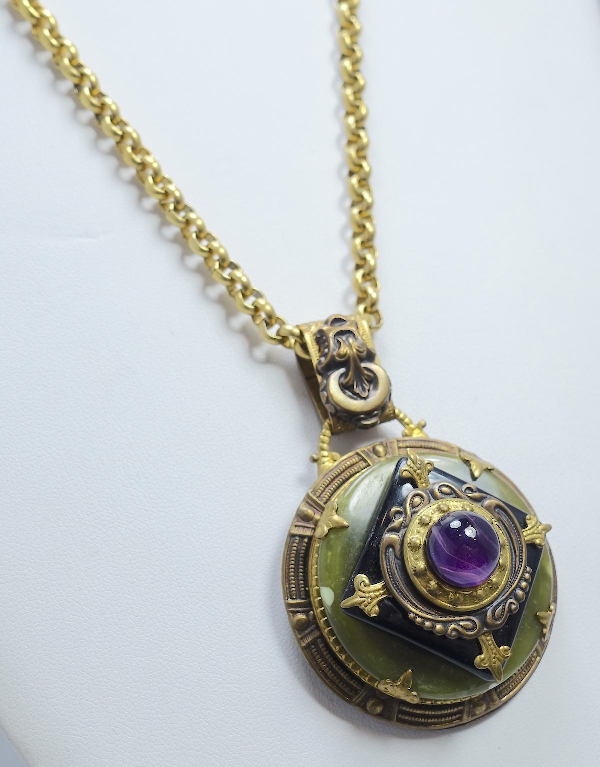 This vintage art deco pendant necklace features a large center amethyst stone in a 3-dimensional black and green stone design in a gold tone setting.  In excellent condition, the pendant measures 2-1/2” x 1-3/4”; the gold-tone link chain is 32” x