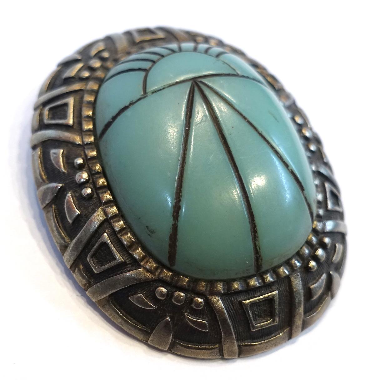 This vintage signed Hobe brooch-pendant features a carved faux turquoise stone in a sterling silver setting.  It can be worn as a brooch or a pendant.  It measures 2-1/4” x 1-7/8” and is signed “Hobe”. This piece is in excellent condition.