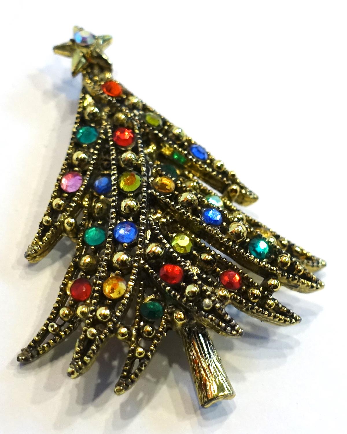 This is a famous vintage Christmas tree brooch by Hollycraft. It has multi-color crystals decorating the tree in a gold tone setting.  This brooch measures 2-1/8” x 1-5/8” and is signed “Hollycraft”. It is in excellent condition.