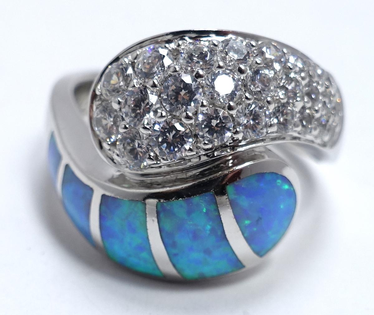 This vintage ring is designed with opals with clear crystal accents in a sterling silver setting.  A size 10, this ring measures 3/4” wide and is in excellent condition.