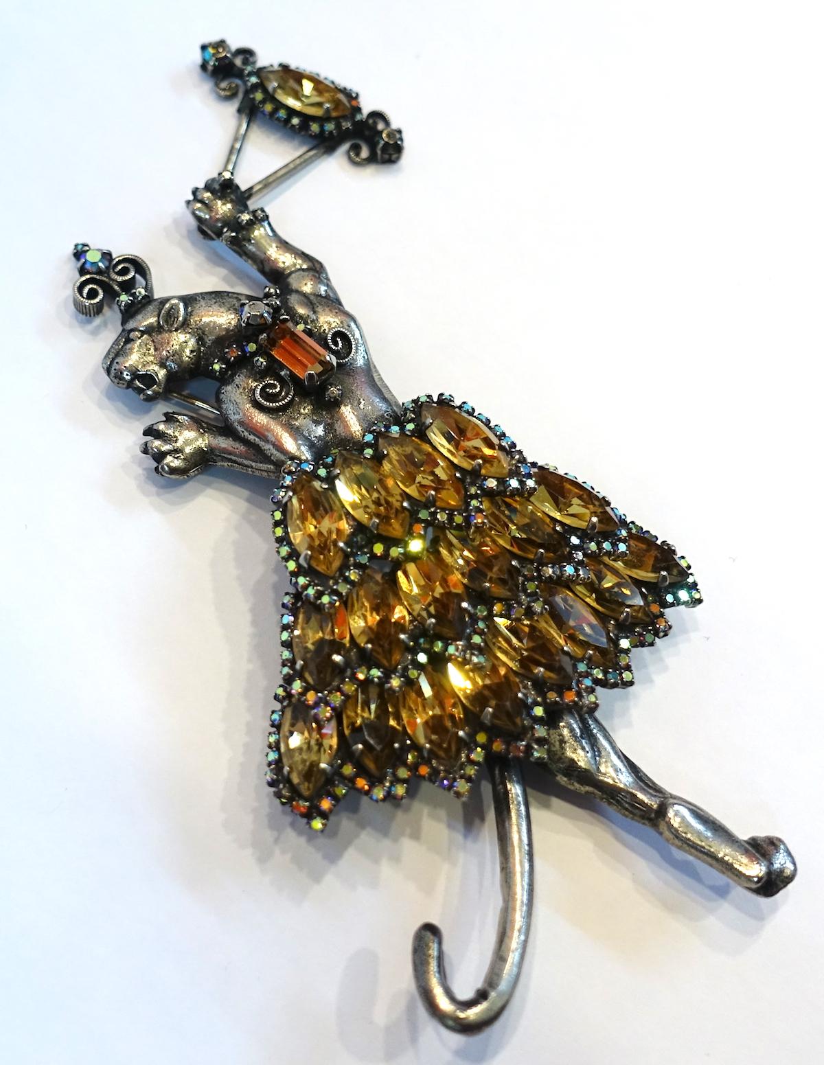 This unique, huge brooch is designed by Danny Pollak.  We believe this is a dancing tiger with citrine skirt and clear crystals made in a sterling silver.  This brooch measures 6” x 2-1/2” and is signed “Pollak”.  It is in excellent condition.