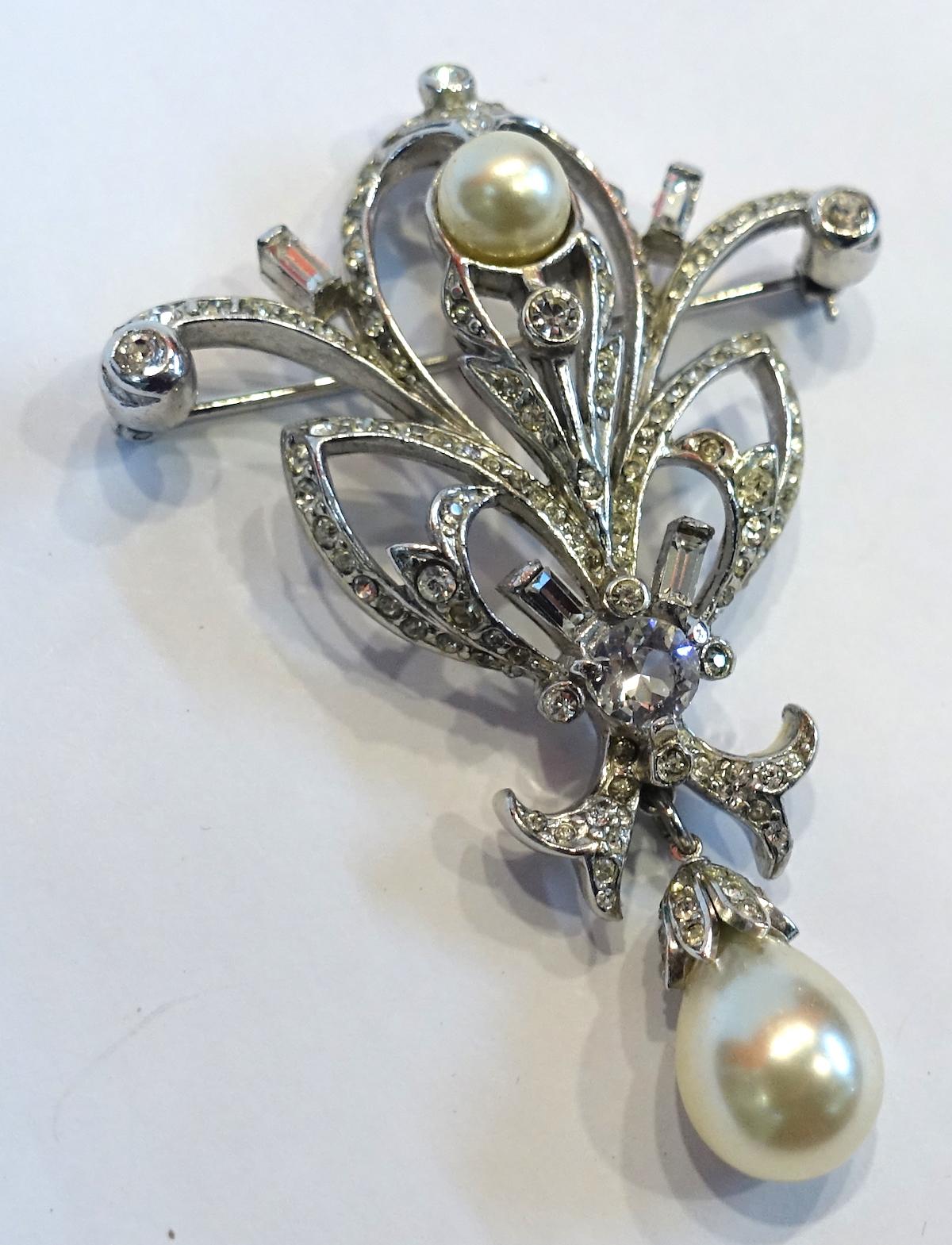This beautiful vintage signed Reja brooch has an intricate design with faux pearls & clear crystals in a rhodium silver tone setting.  The brooch measures 2-3/4” x 1-7/8” and signed “Reja”. It is in excellent condition.