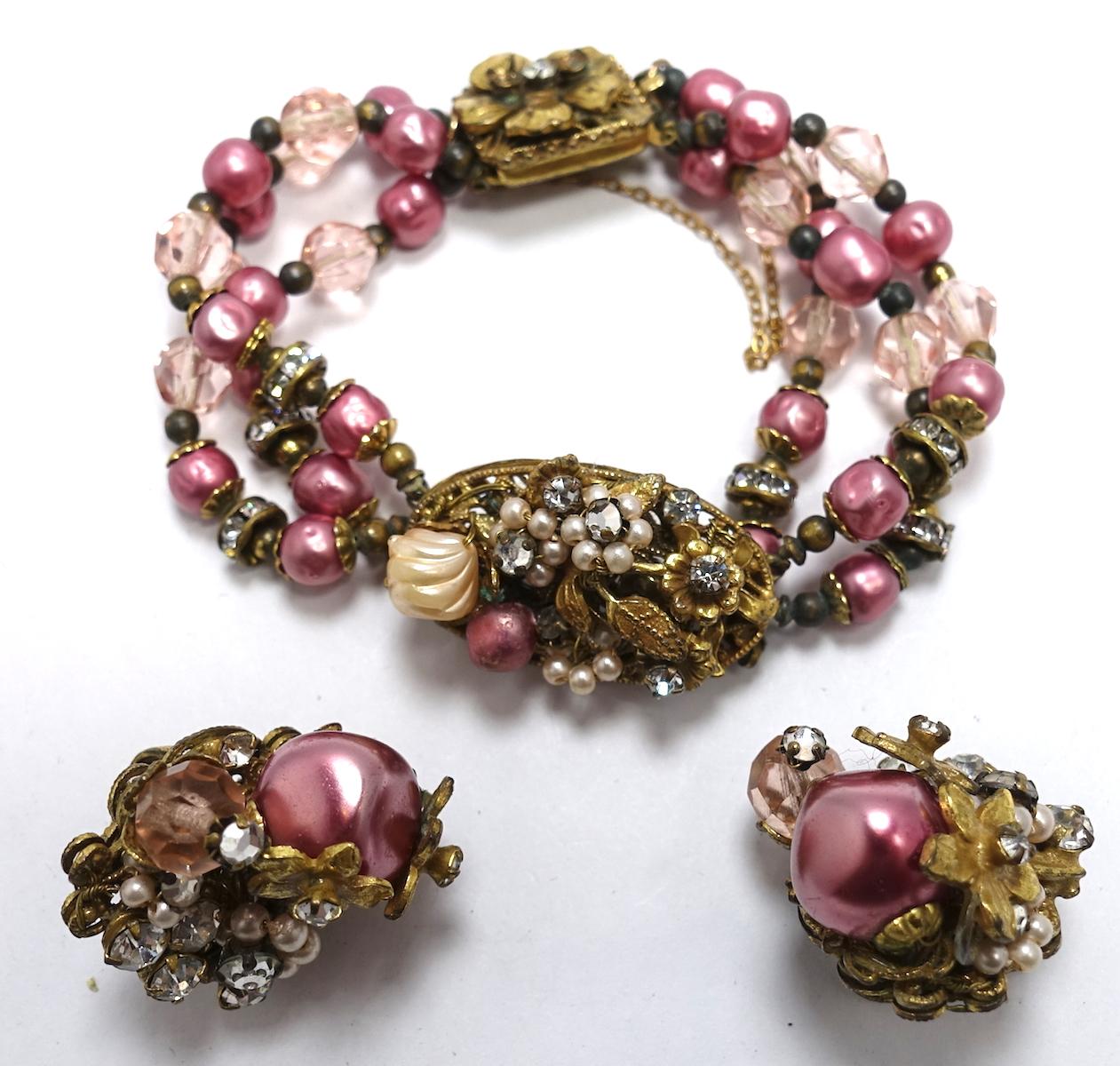 Although this set is not signed, it has all the attributes of “Original by Robert”. The bracelet has a pink stones with clear crystal accents in a gold tone filigree setting. The bracelet measures 7” x 3/4” with a slide in clasp with a safety chain.