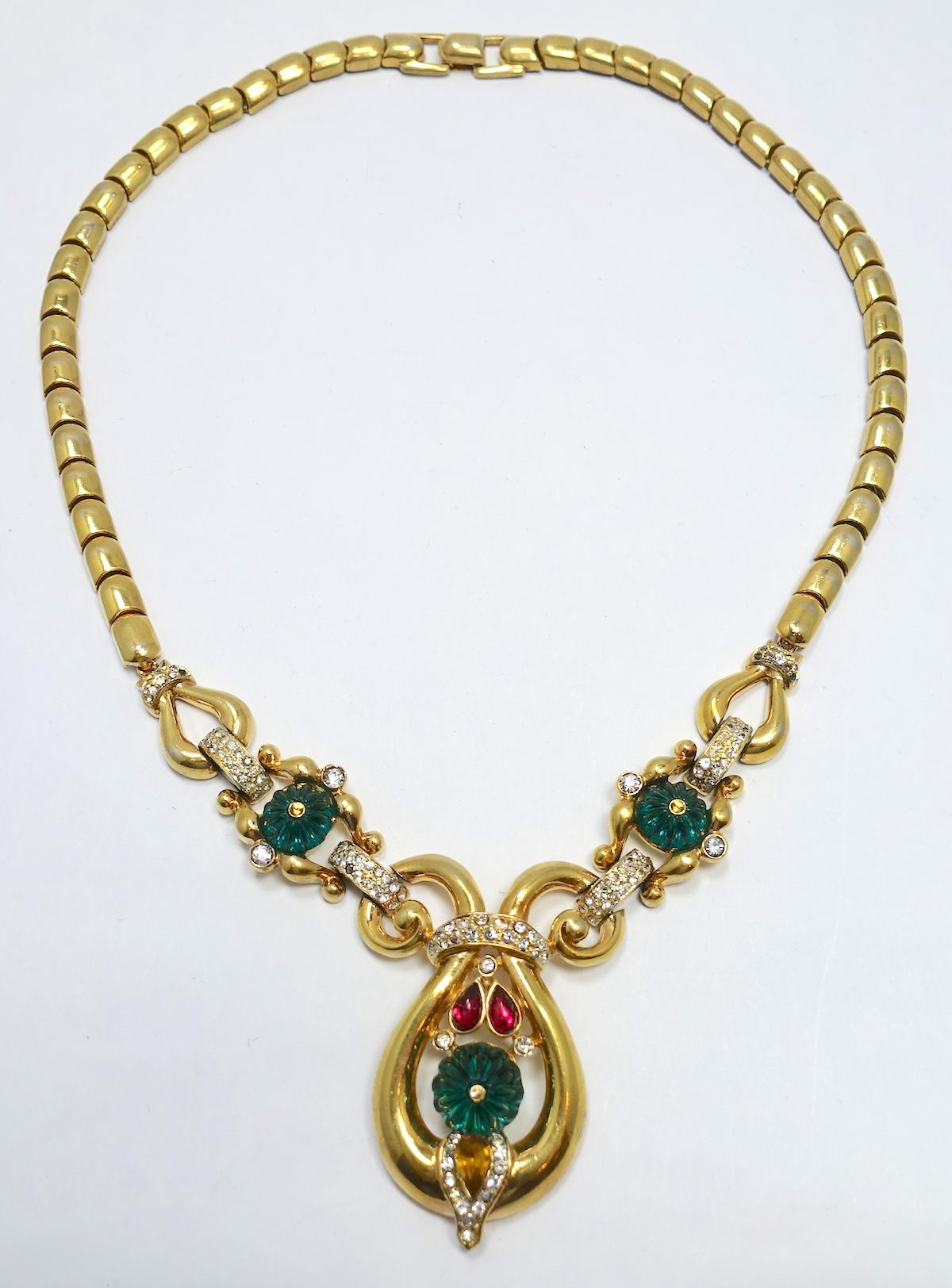This vintage signed Trifari necklace is famous and featured in many books. It has Trifari’s famous mogul design with red, green and clear rhinestones in a gold tone setting. This necklace measures 16-1/2” long with a fold-over clasp. The front drop