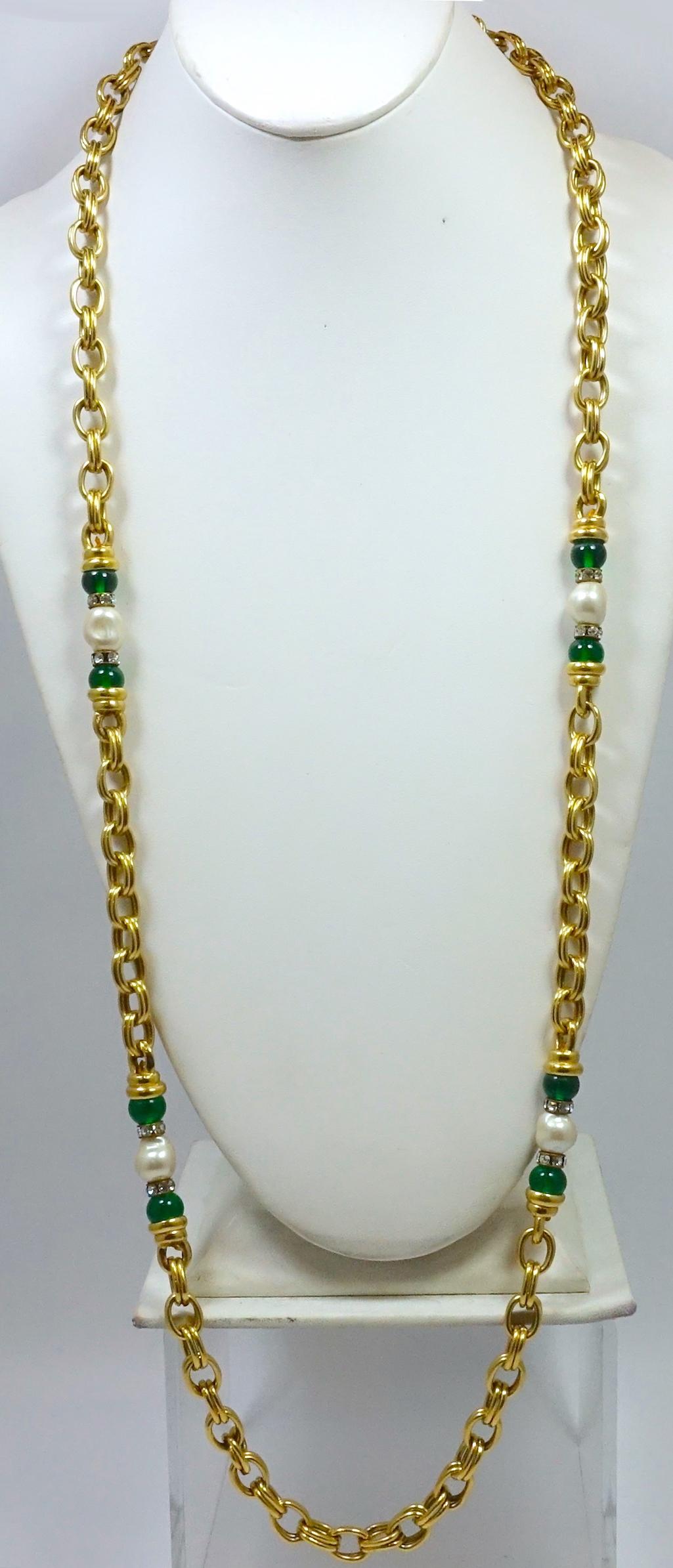 This vintage sautoir necklace has the look of Chanel. It is designed with a heavy link chain with faux pearls and green beads with clear crystal accents.  It is set in a gold tone metal and measure 38” x 3/8”. This sautoir necklace is in excellent