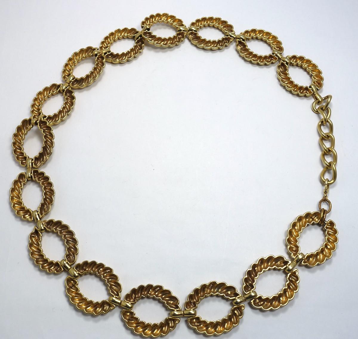This vintage 1960s belt features a ribbed large link design in a gold tone metal setting.  In excellent condition, this belt measures 37” x 1-3/4” with an adjustable spring closure.