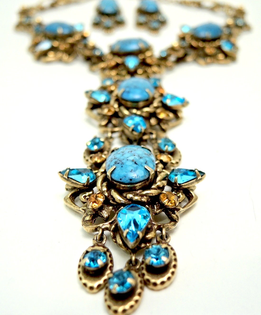 This vintage signed Christian Dior by Kramer necklace features faux turquoise stones with blue and citrine color rhinestones in a gold-tone setting.  This necklace measures 16” with a hook closure; the front drop is 5 ½” x 1 ½”.  The pierced