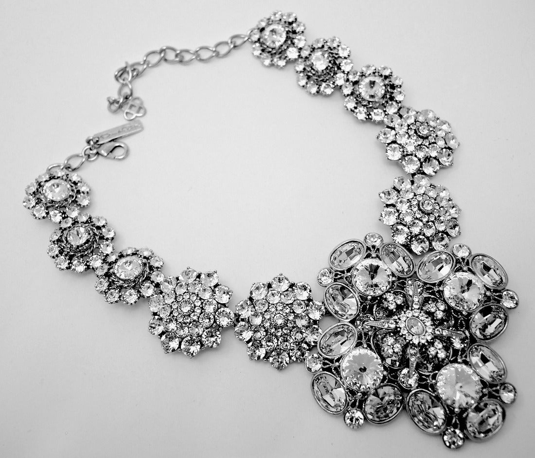 ThIs vintage signed Oscar de la Renta necklace features clear rhinestones in a silver-tone setting. This necklace measures 19” with a spring closure and the centerpiece is 3 ½” wide.  In excellent condition, this necklace is signed “Oscar de la