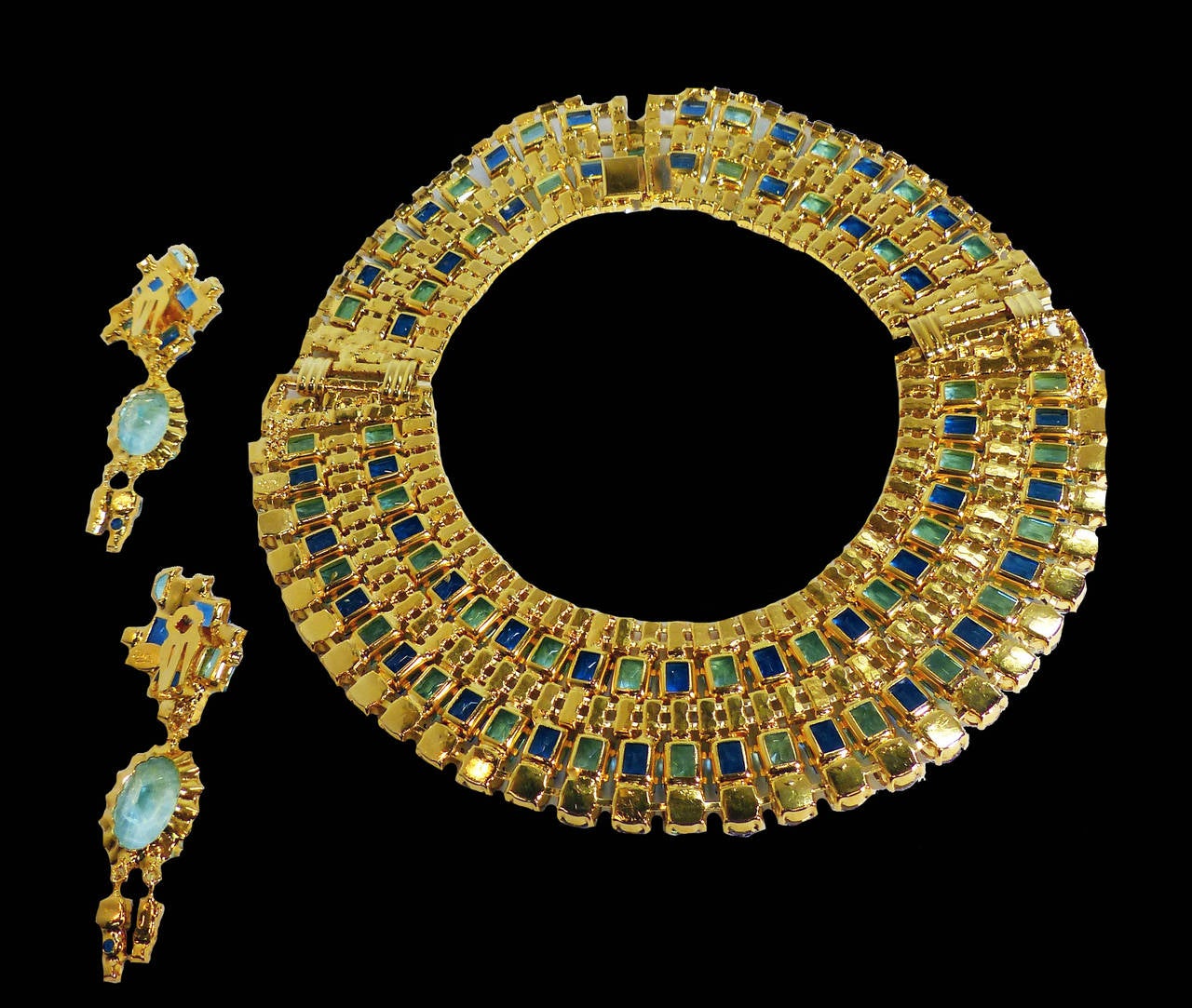 This one-of-a-kind set by Robert Sorrell features blue, green and clear crystals in a gold-tone setting.  The necklace measures 16” x 1 ¾” with a pressure closure; the clip earrings are 3 ¼” x 1 ¼”.  In excellent condition, this set is signed