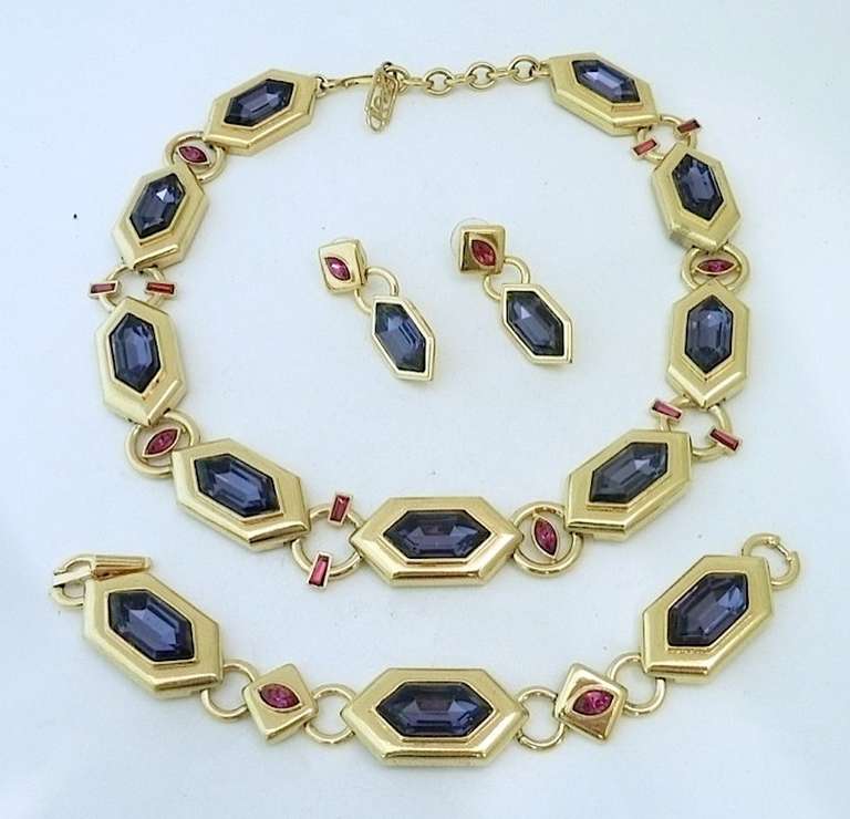 This beautifully made vintage signed Yves St. Laurent set features amethyst and red color rhinestones in a gold-tone setting. The necklace measures 18” x ¾” with a hook closure; the bracelet is 7” x ¾” with a fold-over closure and the pierced