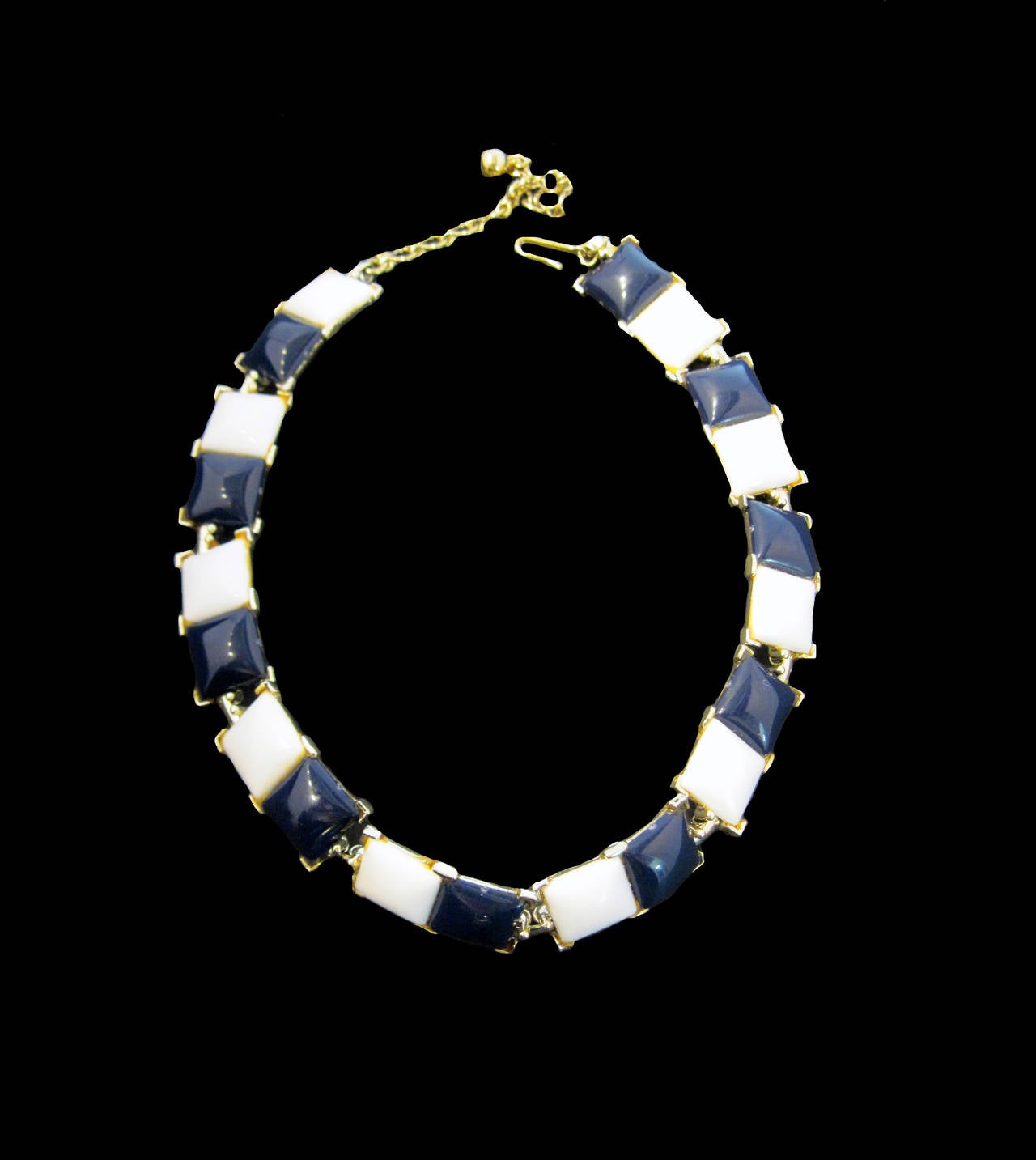 This vintage signed Kramer set features navy blue and white enameled resin stones in a gold-tone setting.  The necklace measures 16 ½” x ½” with a hook closure; the bracelet measures 7” x 1” with a fold-over closure.  In excellent condition, this