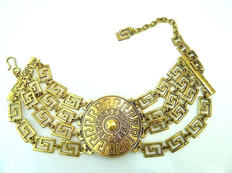 This vintage signed Versace necklace features the famous Versace geometric design in a gold-tone setting. In excellent condition, this necklace measures 17” with a hook closure and the centerpiece is 2 ¼” in diameter. In excellent condition, this