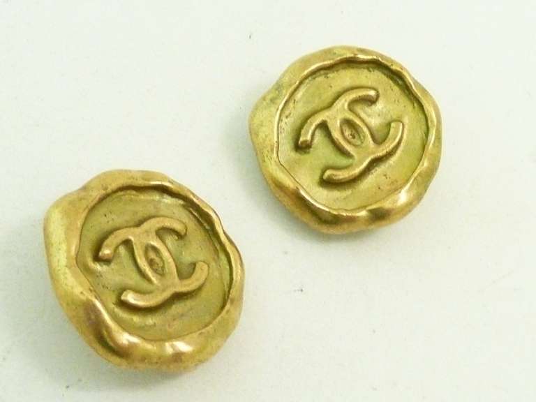 These vintage signed Chanel earrings feature the famous CC logo in a gold-tone setting.  In excellent condition, these clip earrings measure 1” in diameter and are signed Chanel 95P Made in France.